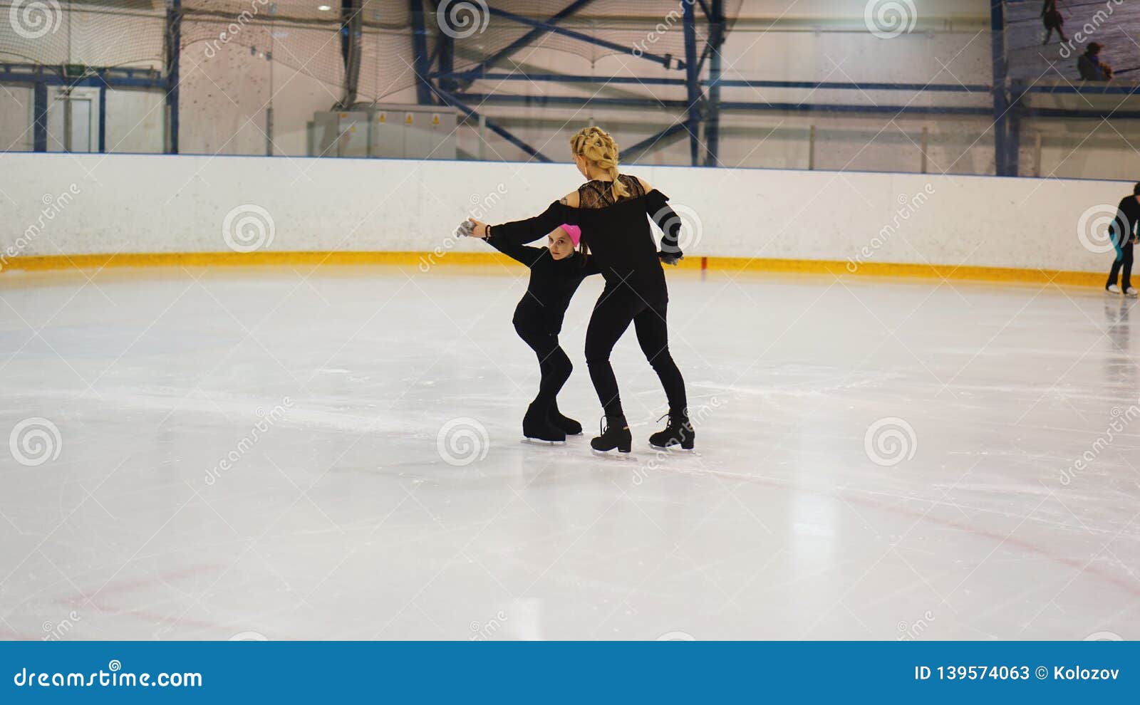 Coche Femenino En Niña De Entrenamiento Del Patinaje Artístico En La Pista  Interior Imagen de archivo - Imagen de hielo, interior: 139574063