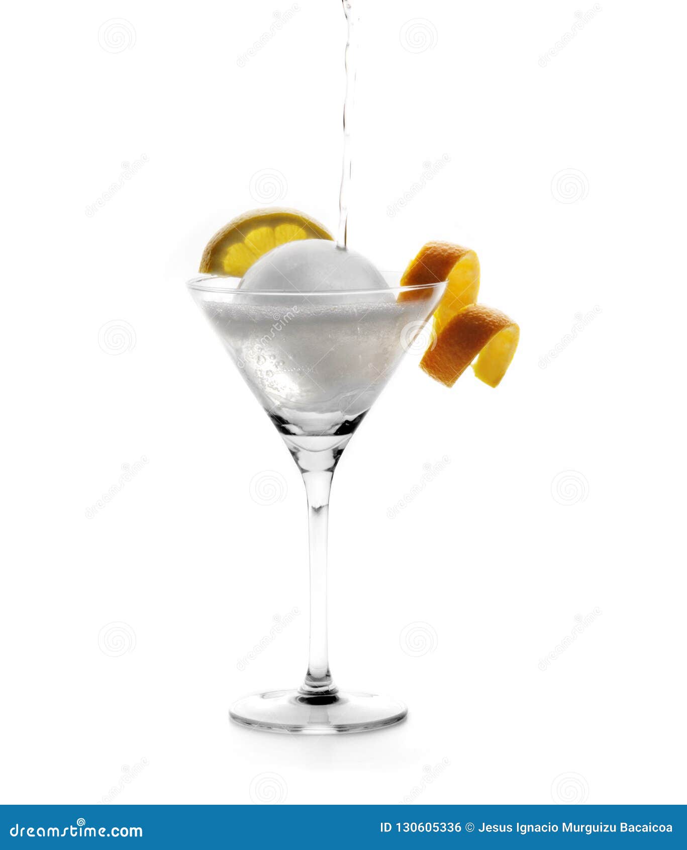 cocktail glass with slices of lemon and orange with a large round ice