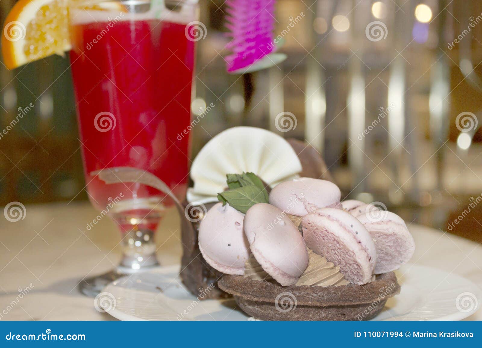 a cocktail and a cake lying on the plate with a basket of mering
