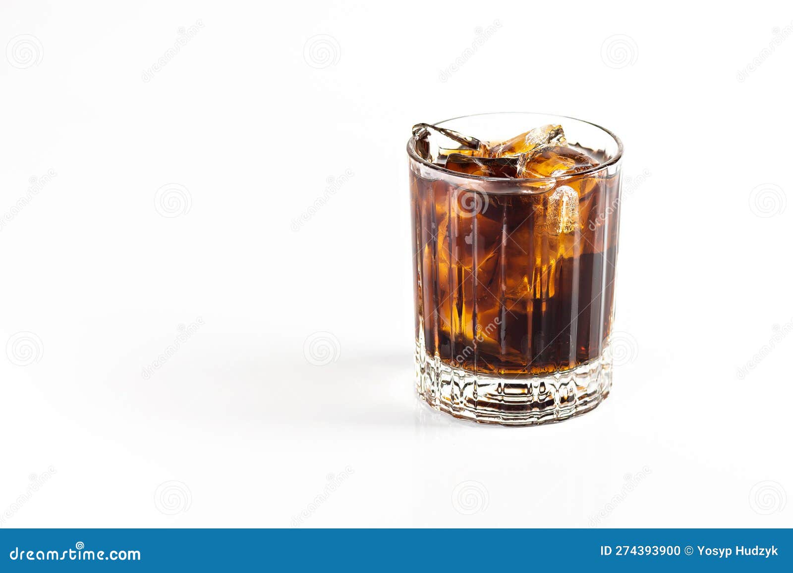 A Cocktail of Whiskey and Cola is Decorated with a Large Ice Cube. on a