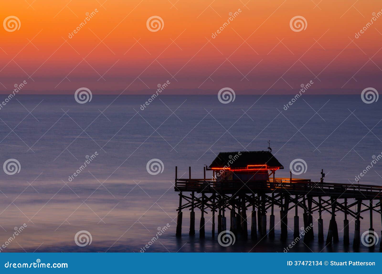 Cocoa Beach Florida Pier with Beautiful Sunset. The Cocoa Beach Pier with a beautiful sunset and the orange glow of the tiki bar.