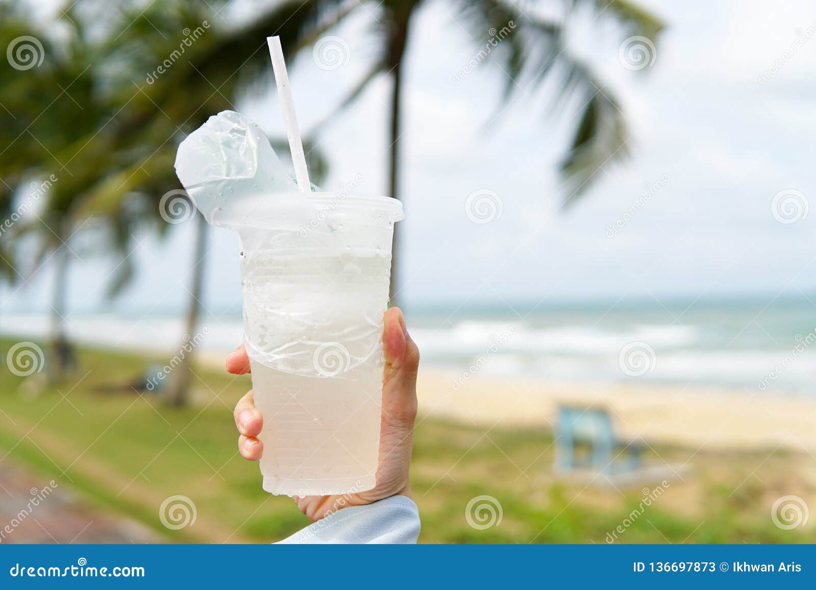 coconut juice,drink coconut water in transparent plastic container with beach background - image