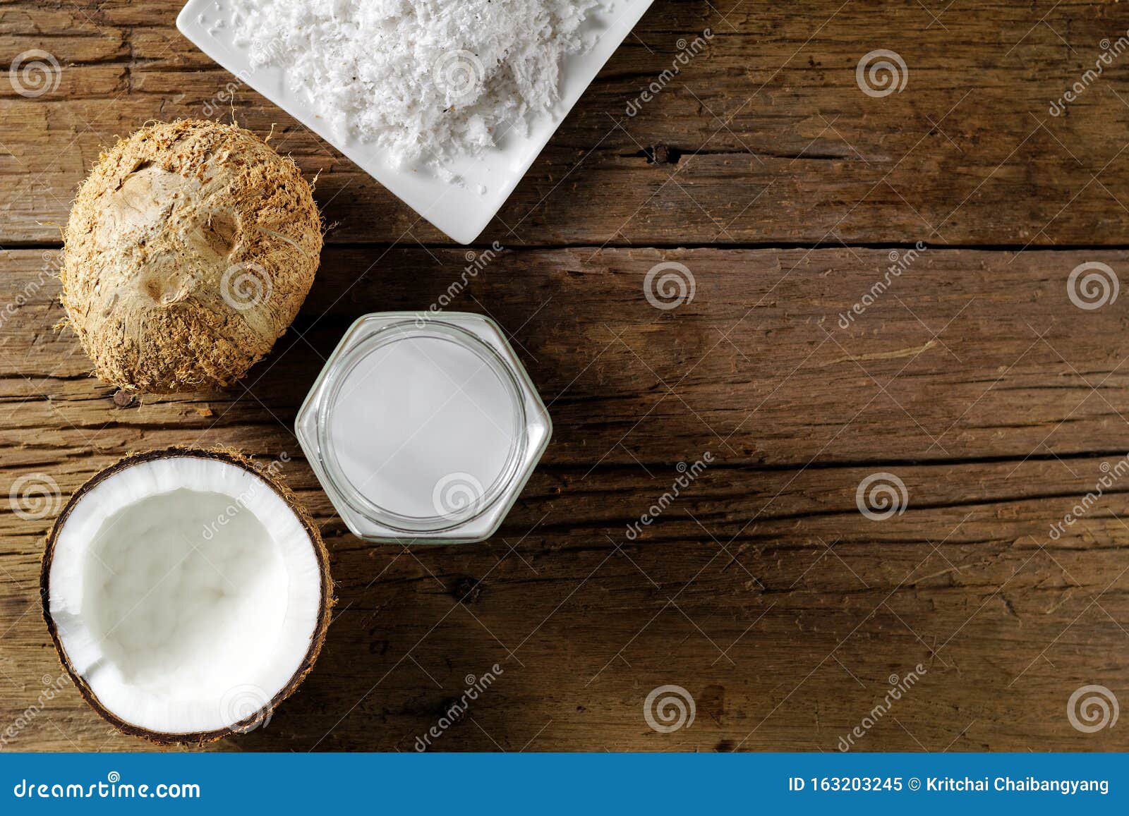 Coconut Milk in a Jar with Full and Half Coconut Fruit on Dark Wooden