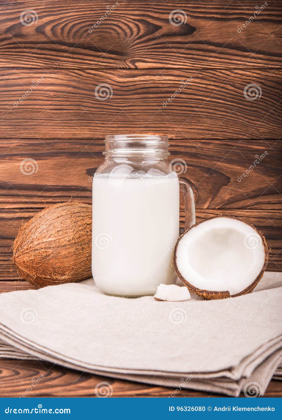 Coconut Vegan Milk in a Mason Jar and Coconuts on a Gray Fabric and