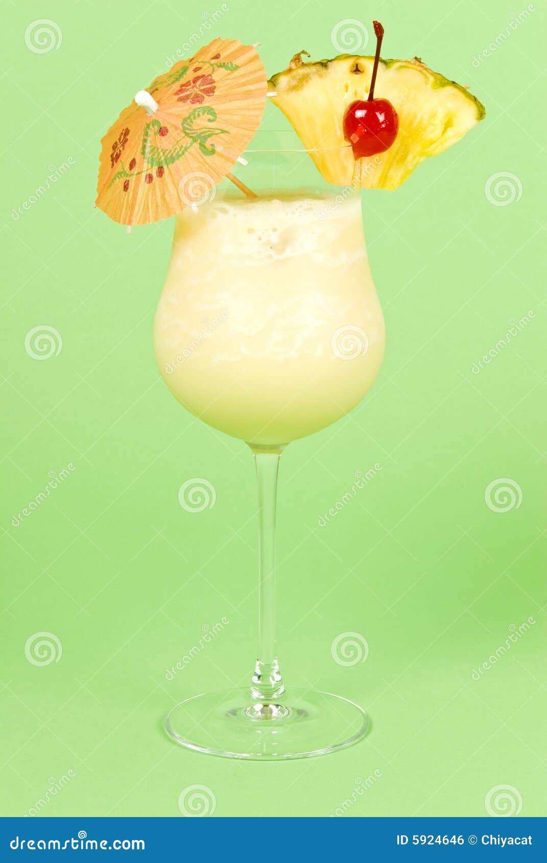 Coctel de Pina Colada. Vidrio de colada del pina adornado con el paraguas, la rebanada de manzana del pino y la cereza de marrasquino.