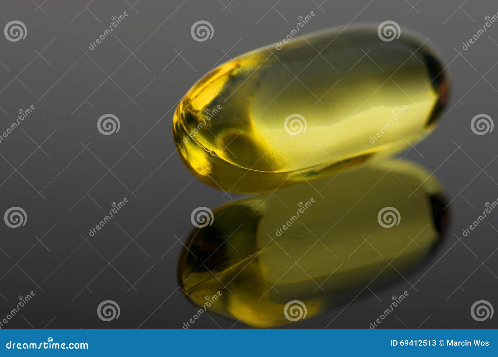 Cod Liver Vitamin D Capsule on Black Reflective Surface Stock Image