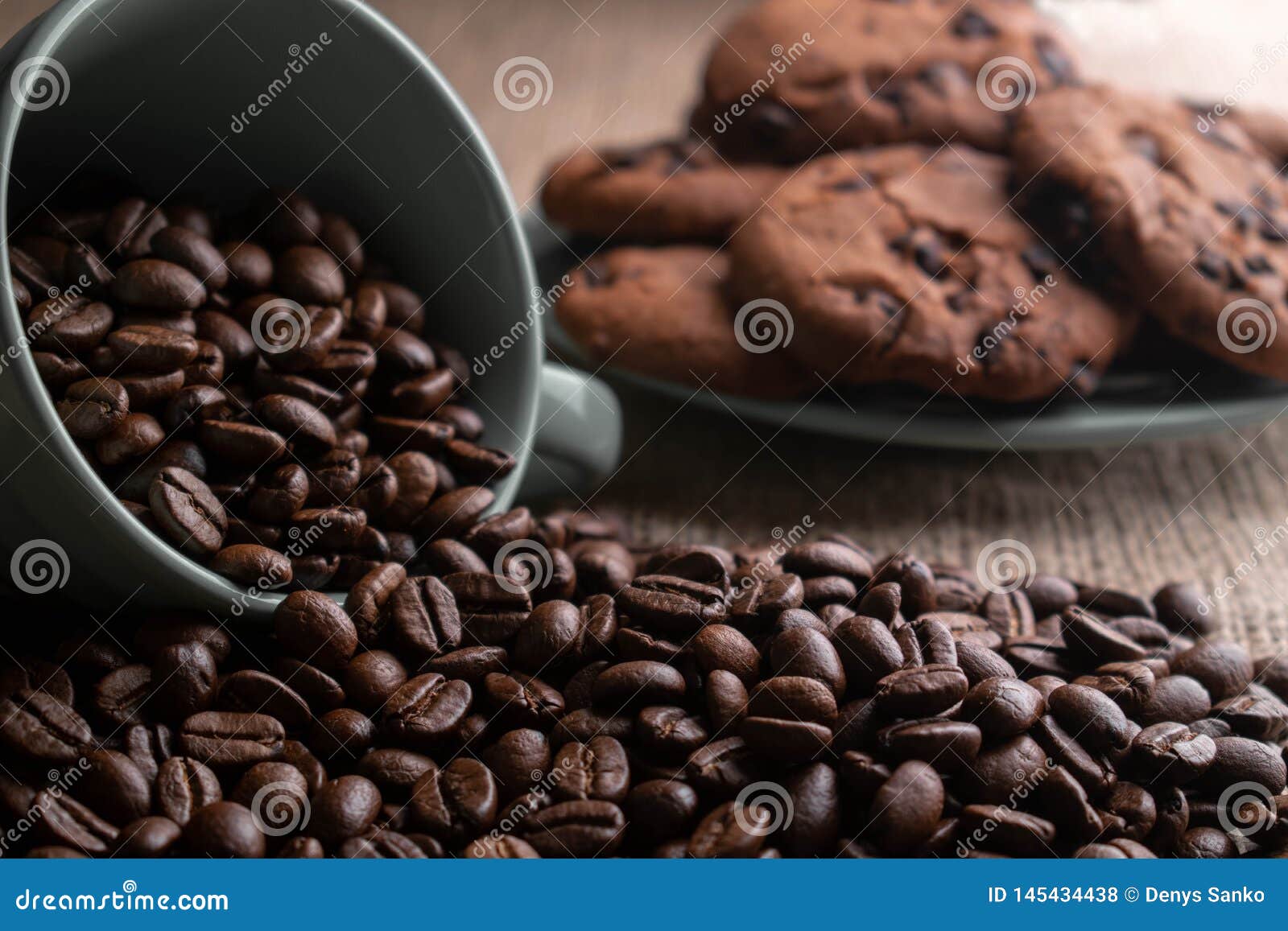 coffee beans crumbled with a cup, in the background a plate of cookies