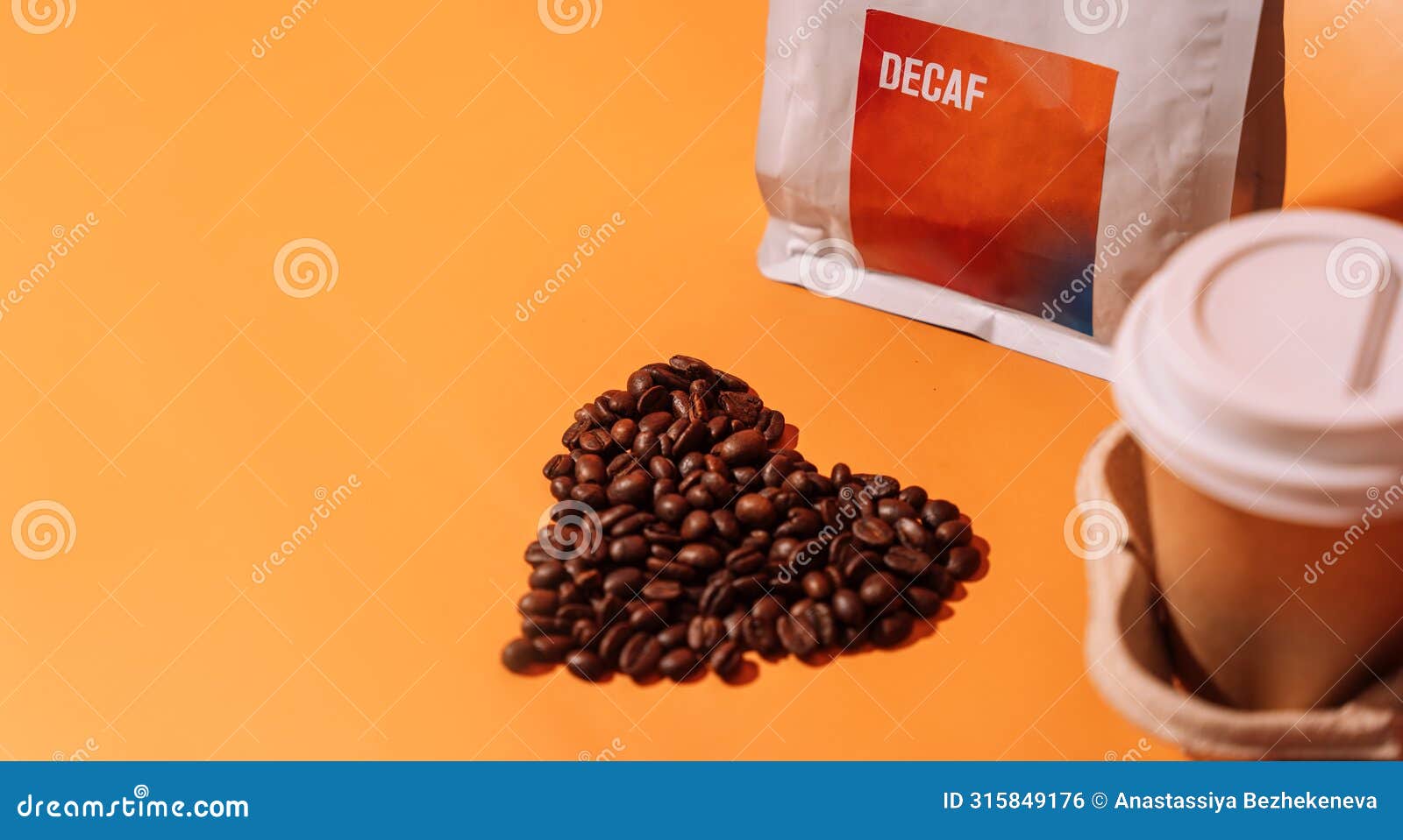 coffee beans in the  of a heart on an orange background next to packaging with text decaf and a paper cup in a tray