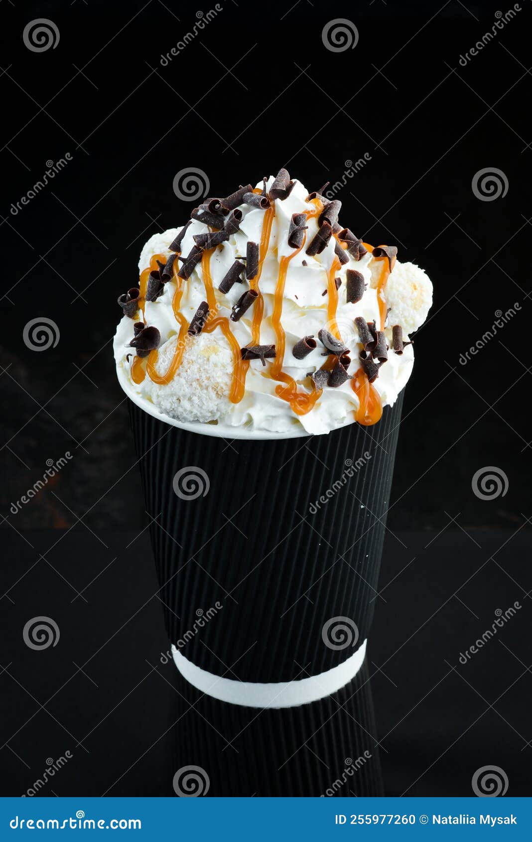 Coffee with Caramel and Cream in a Paper Cup. on a Black Background