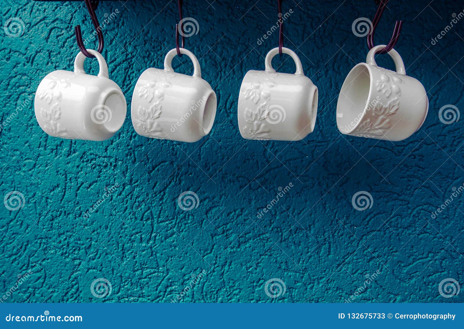 Coffee Cups Hanging on Hooks of Blue Kitchen Wall Modern Interior Stock