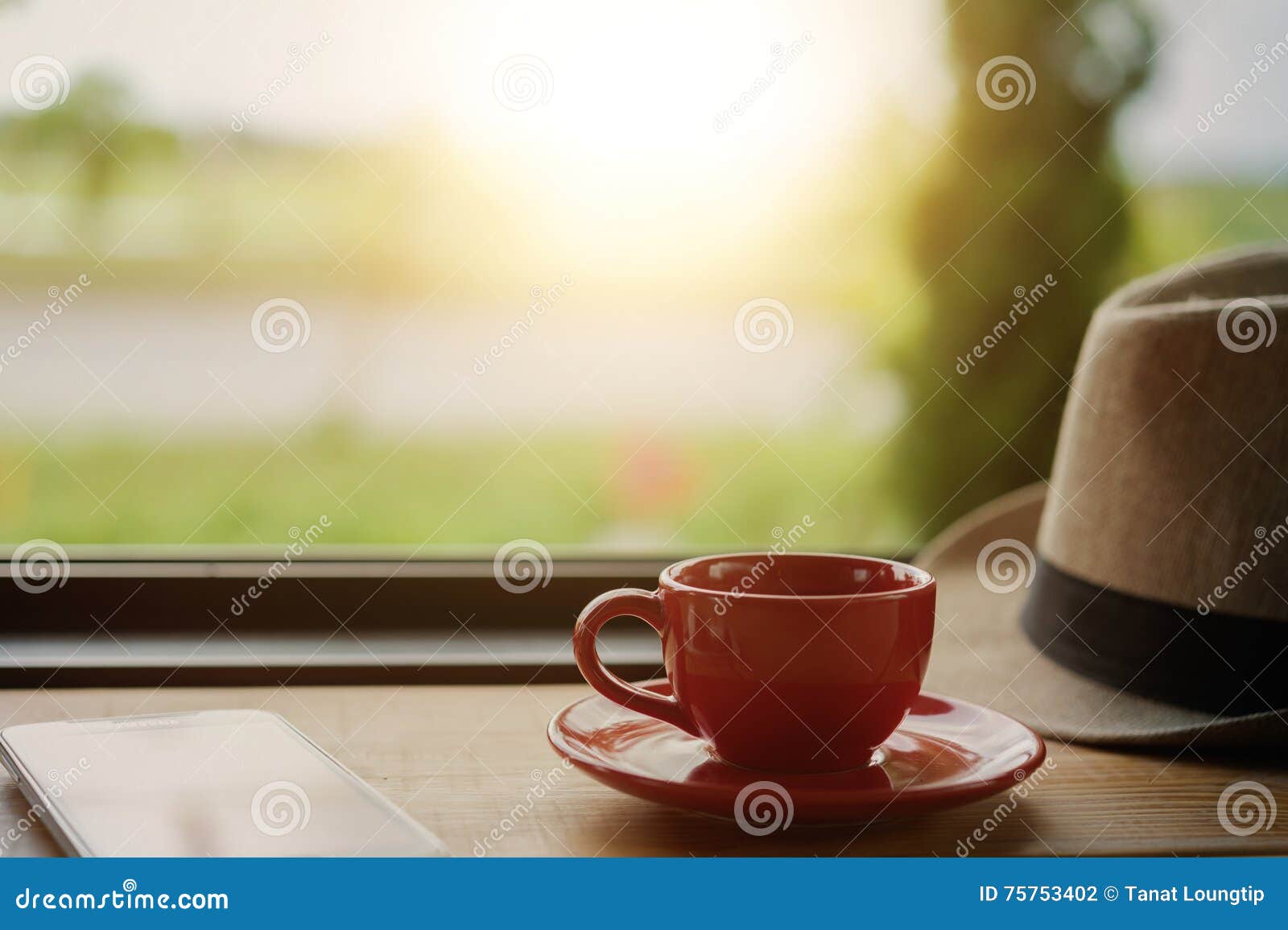 Coffee with Hat and Smart Phone on Coffee Shop Table Stock Photo