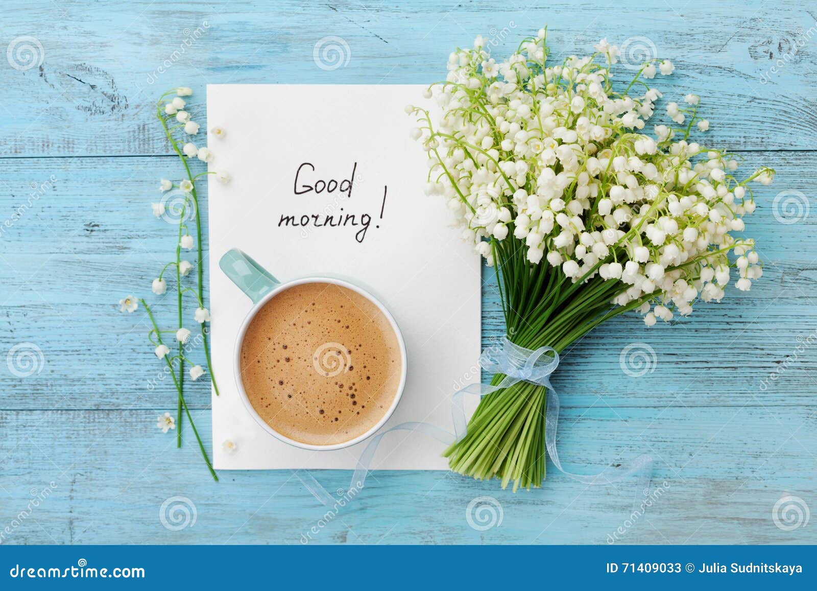 coffee mug with bouquet of flowers lily of the valley and notes good morning on turquoise rustic table from above