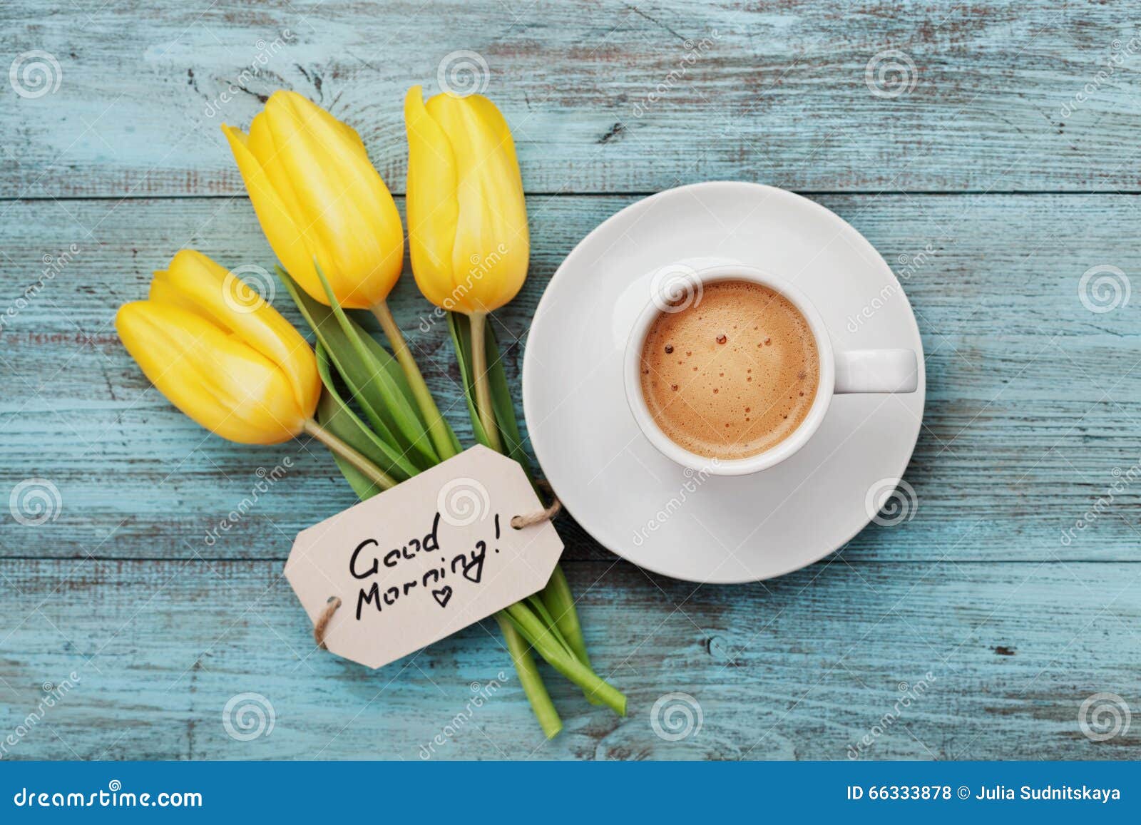 coffee mug with yellow tulip flowers and notes good morning on blue rustic table from above
