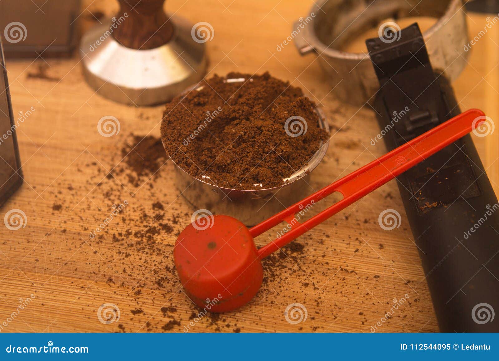 Coffee Tamper with Coffee in Filter Basket and Filter Holder on a