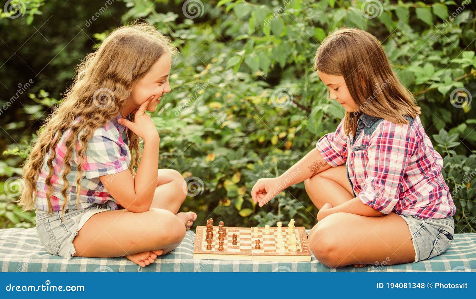 cognitive development. intellectual game. make decision. smart children. children play chess outdoors nature background