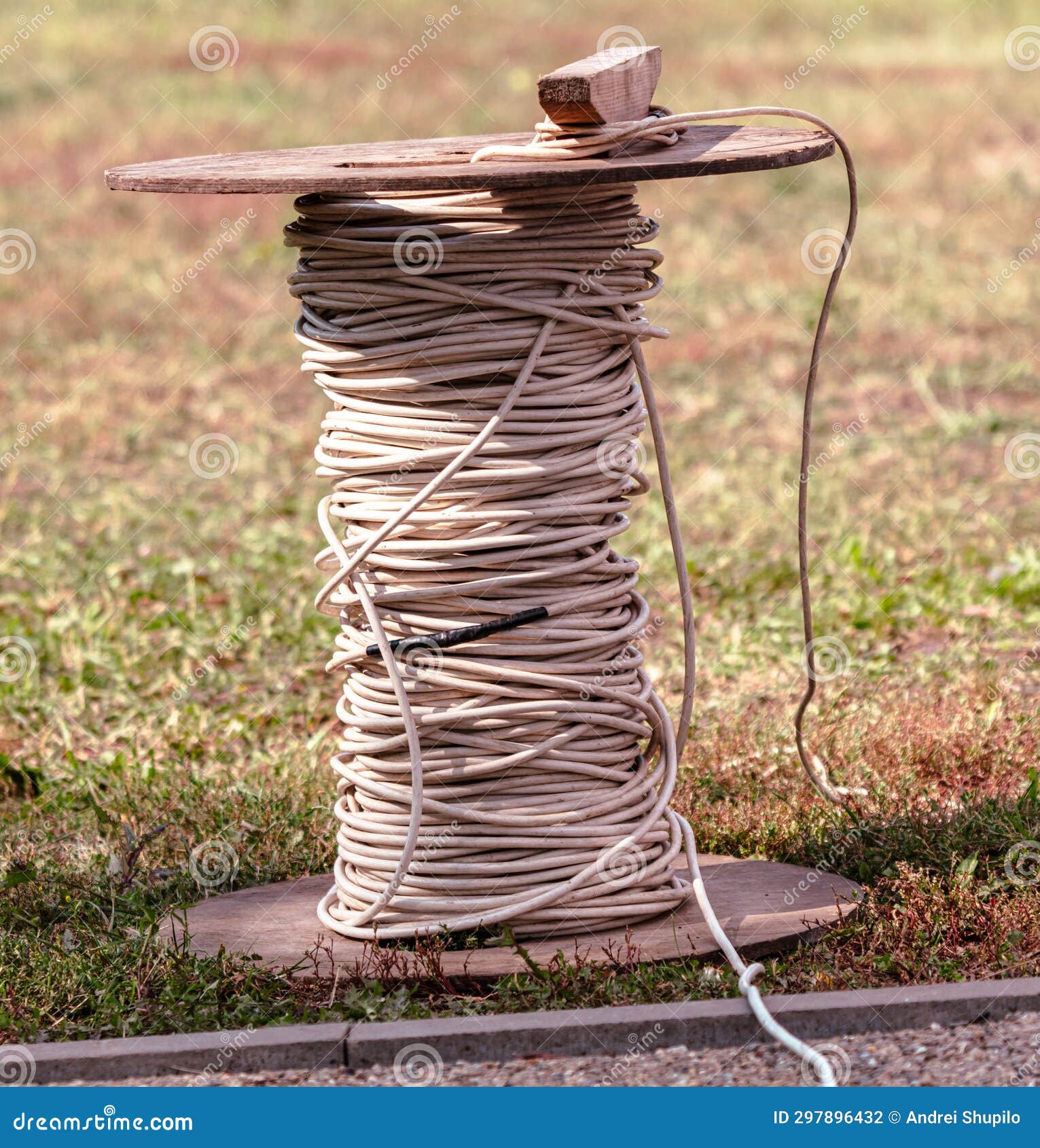 A Coil of Electrical Wire Stands on the Ground in the Park Stock Photo
