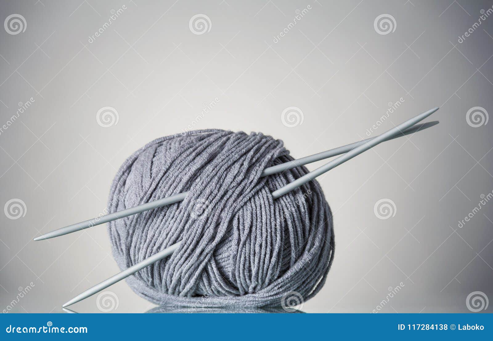 Coil of Gray Yarn and Needles for Needlework, on Gray Stock Photo