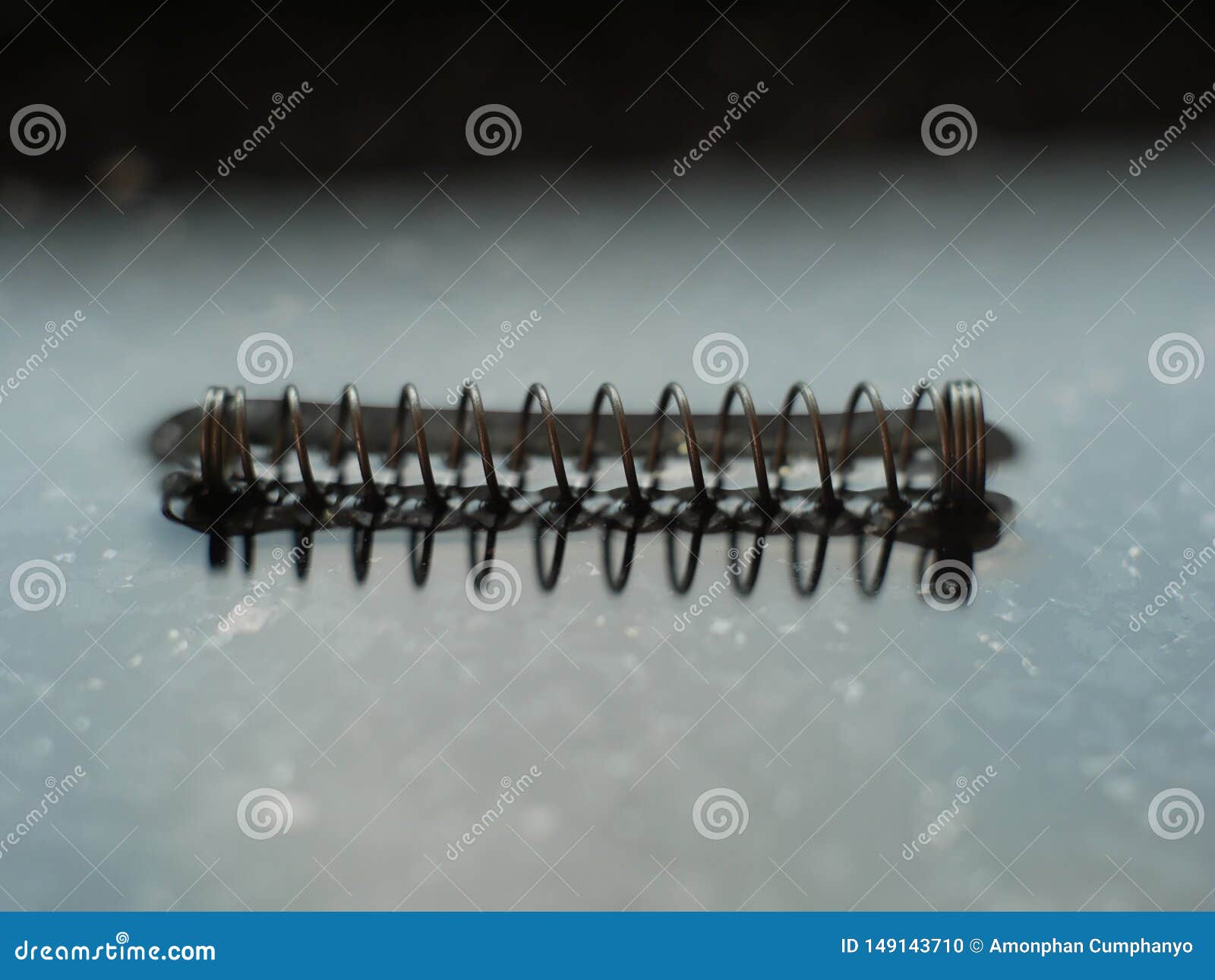 A Coil Spring from a Ballpoint Pen on Abstract Background Stock Photo
