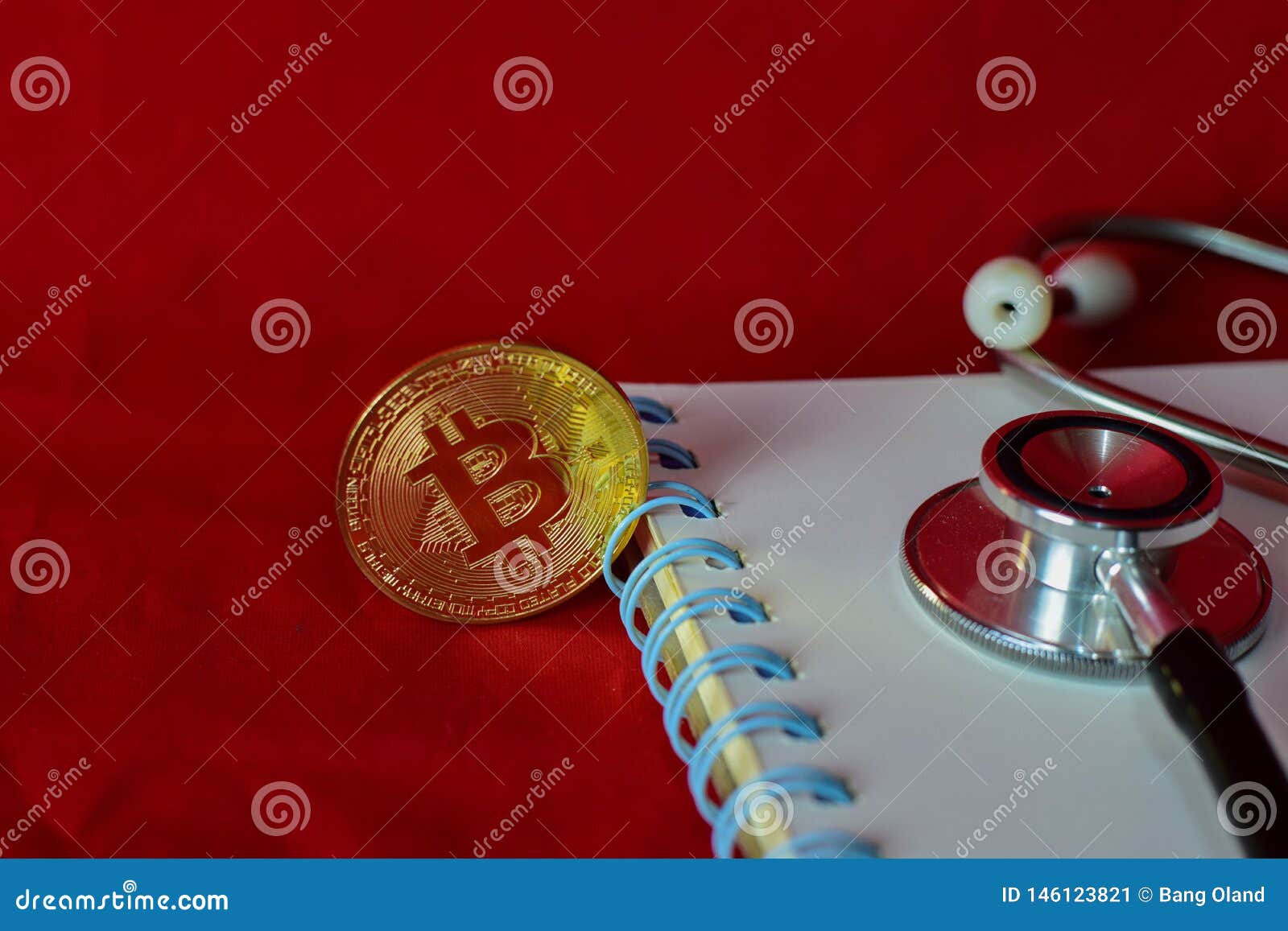 coin bitcoin, notebook,stethoscope and a magnifying glass  on red background