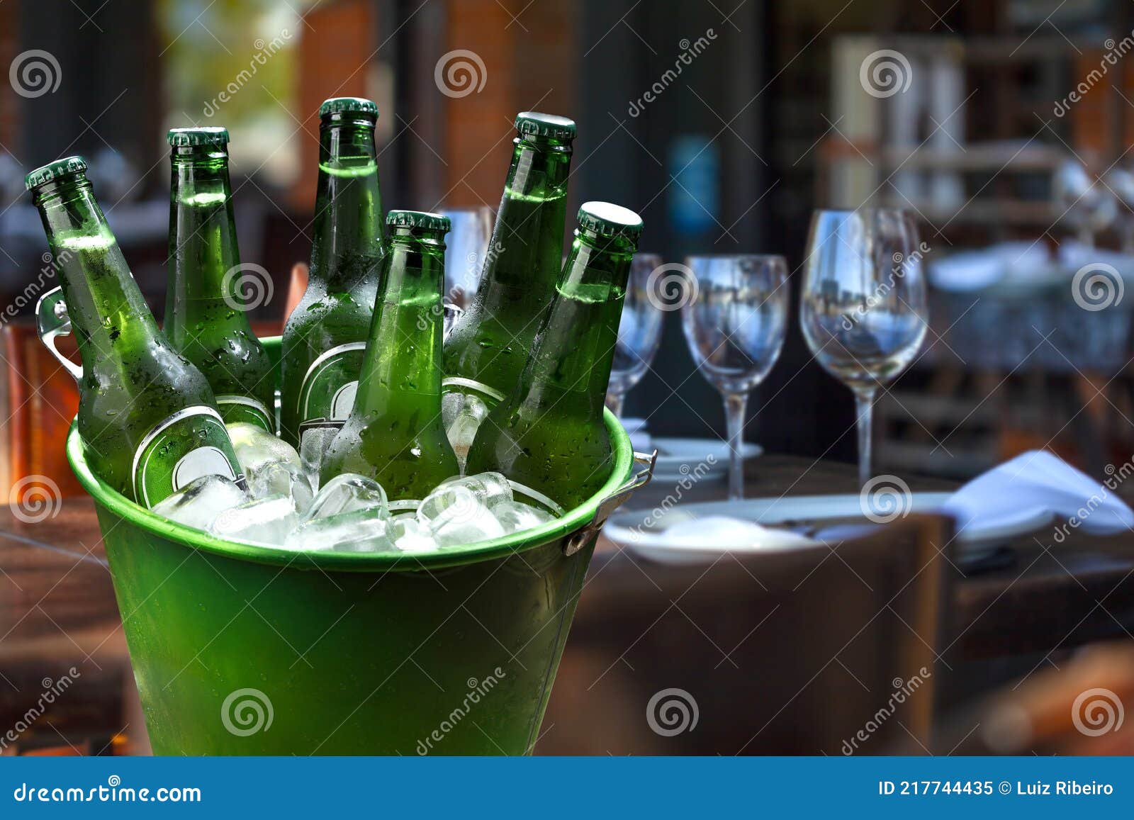 Cold Bottles of Beer in Bucket with Ice in Restaurant Setting Stock