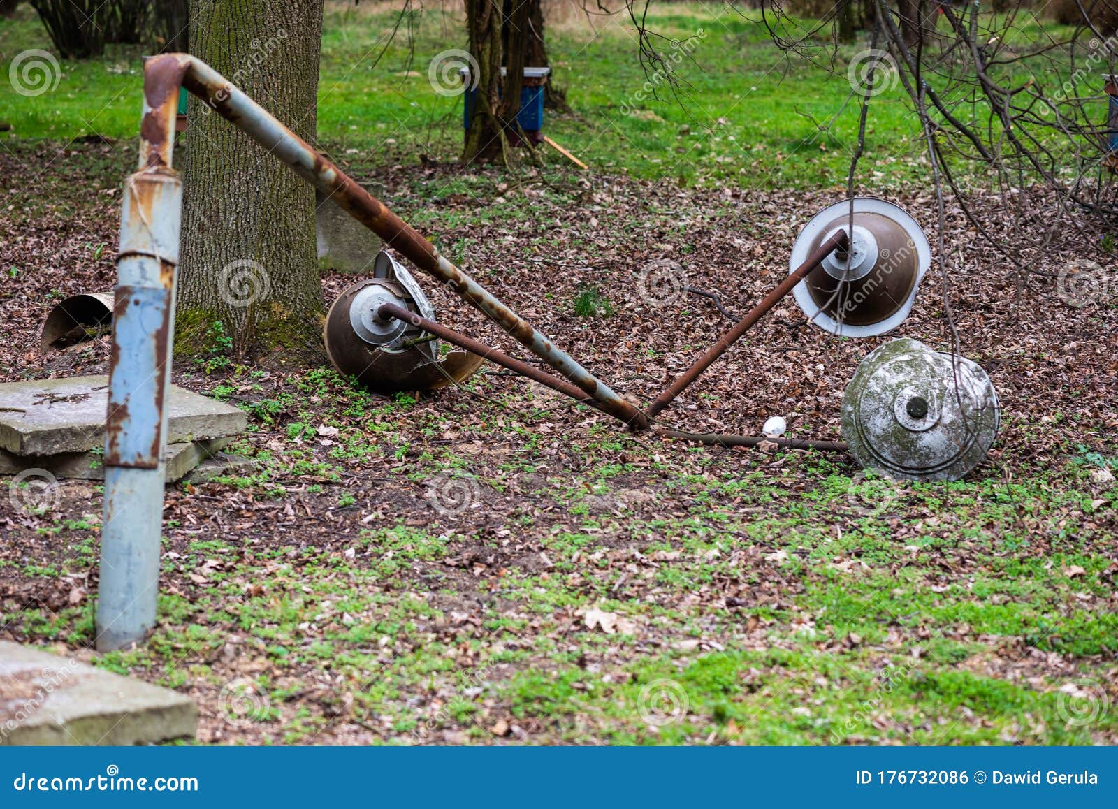 Collapsed Old Rusty Street Lamp among the Greenery in the Park. Broken