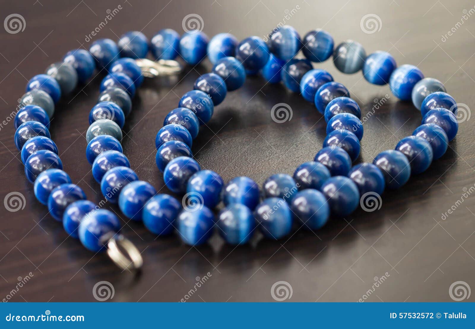 Collar De Un Ojo De Gato De Piedra Del Color Azul En Una Superficie De  Madera Foto de archivo - Imagen de muestra, azul: 57532572