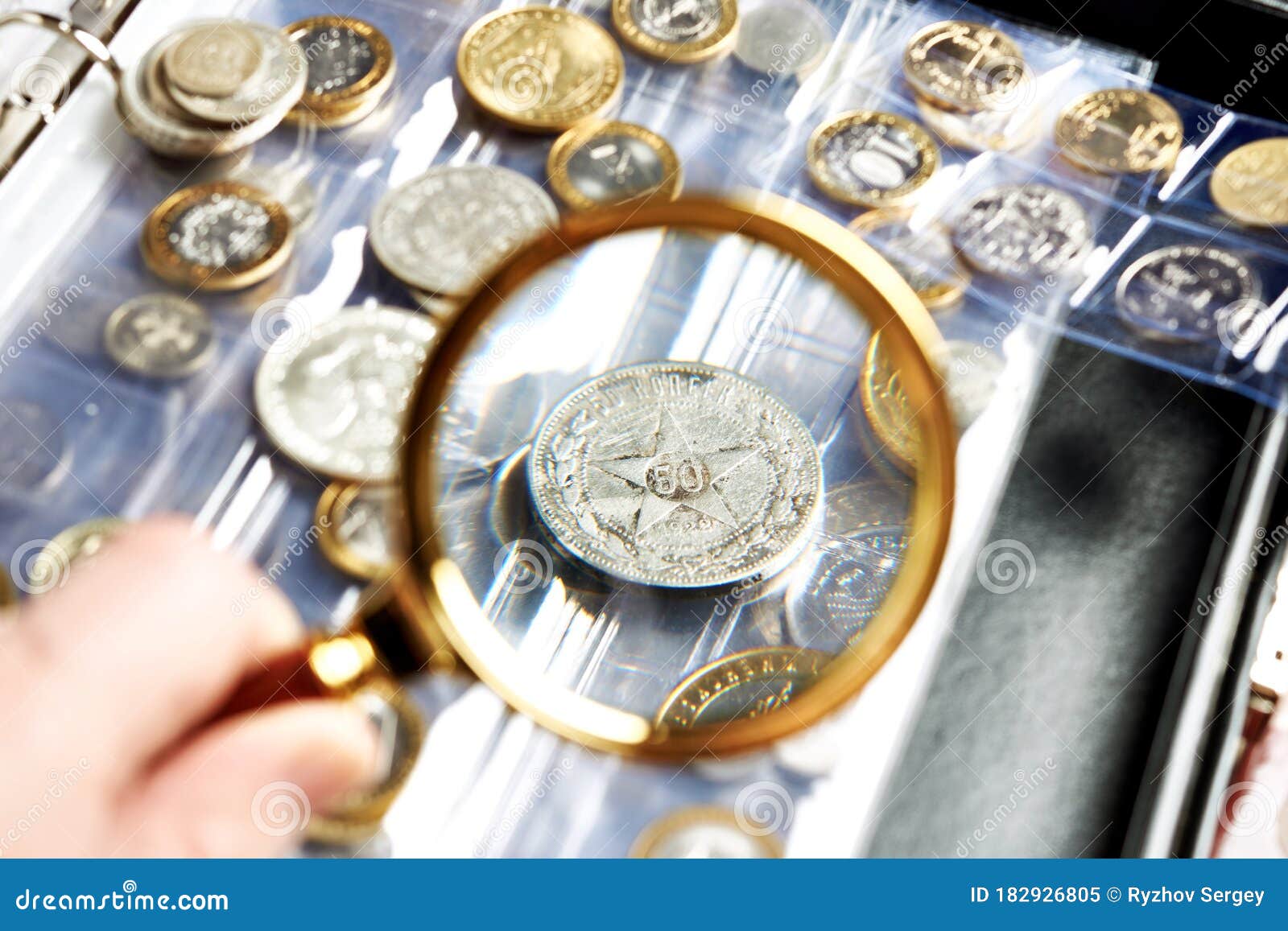 old numismatics silver coins with magnifying glass
