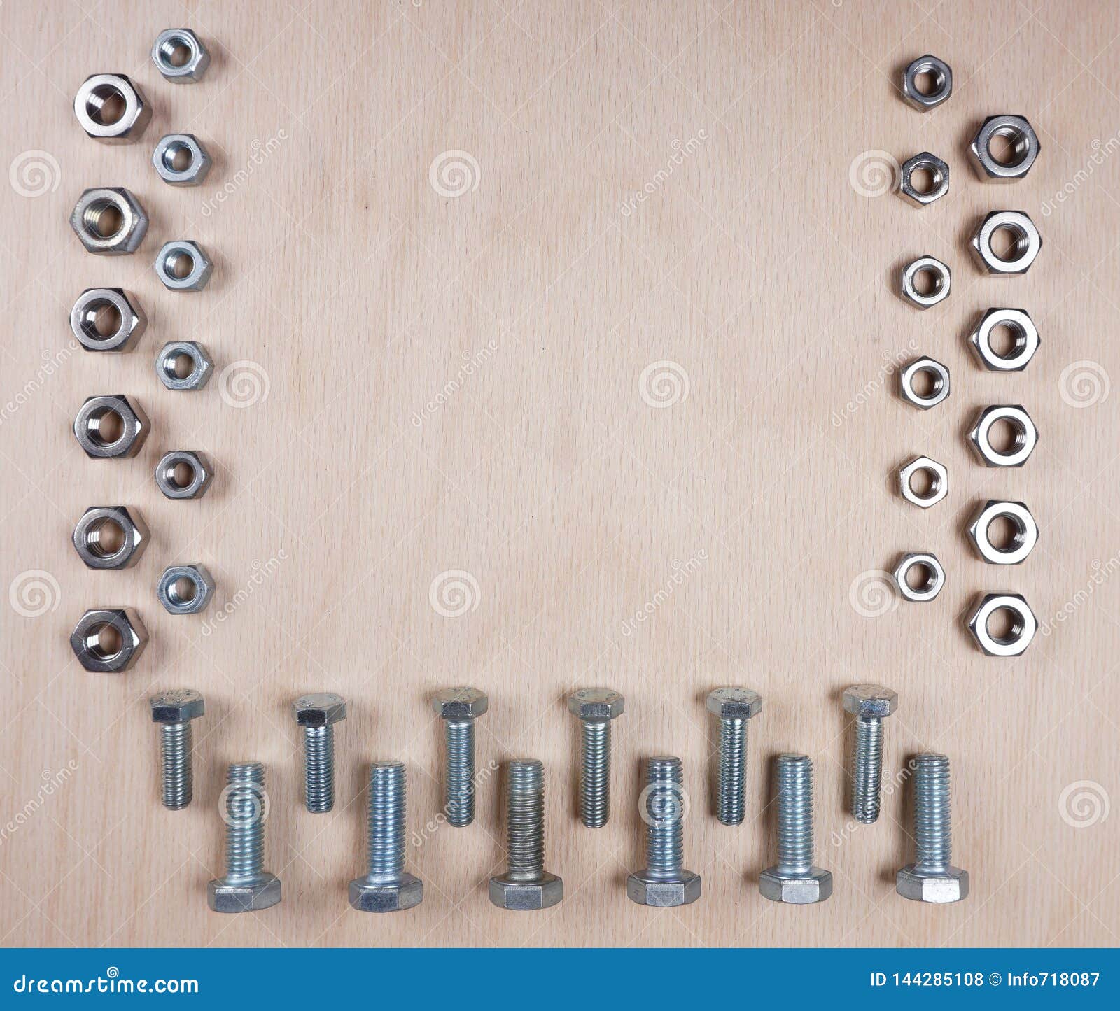 collection of bolts and nuts with copy space for your own text on wooden background