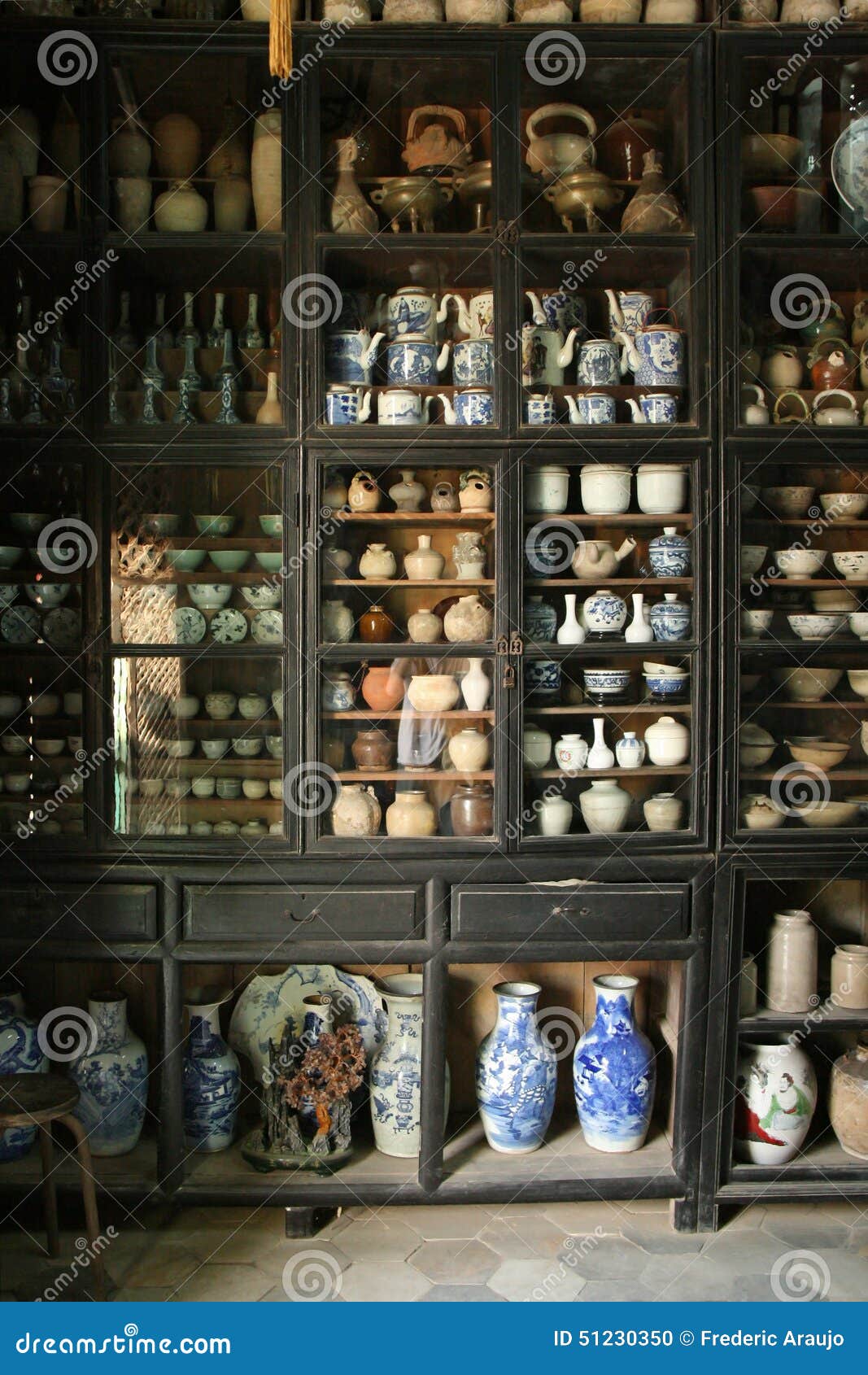 A Collection Of Ceramics Is Exposed In A Display Cabinet In A