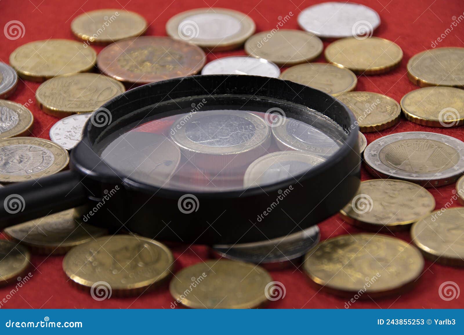 Collection of Coins and Collector Magnifying Glass on Red Stock Image