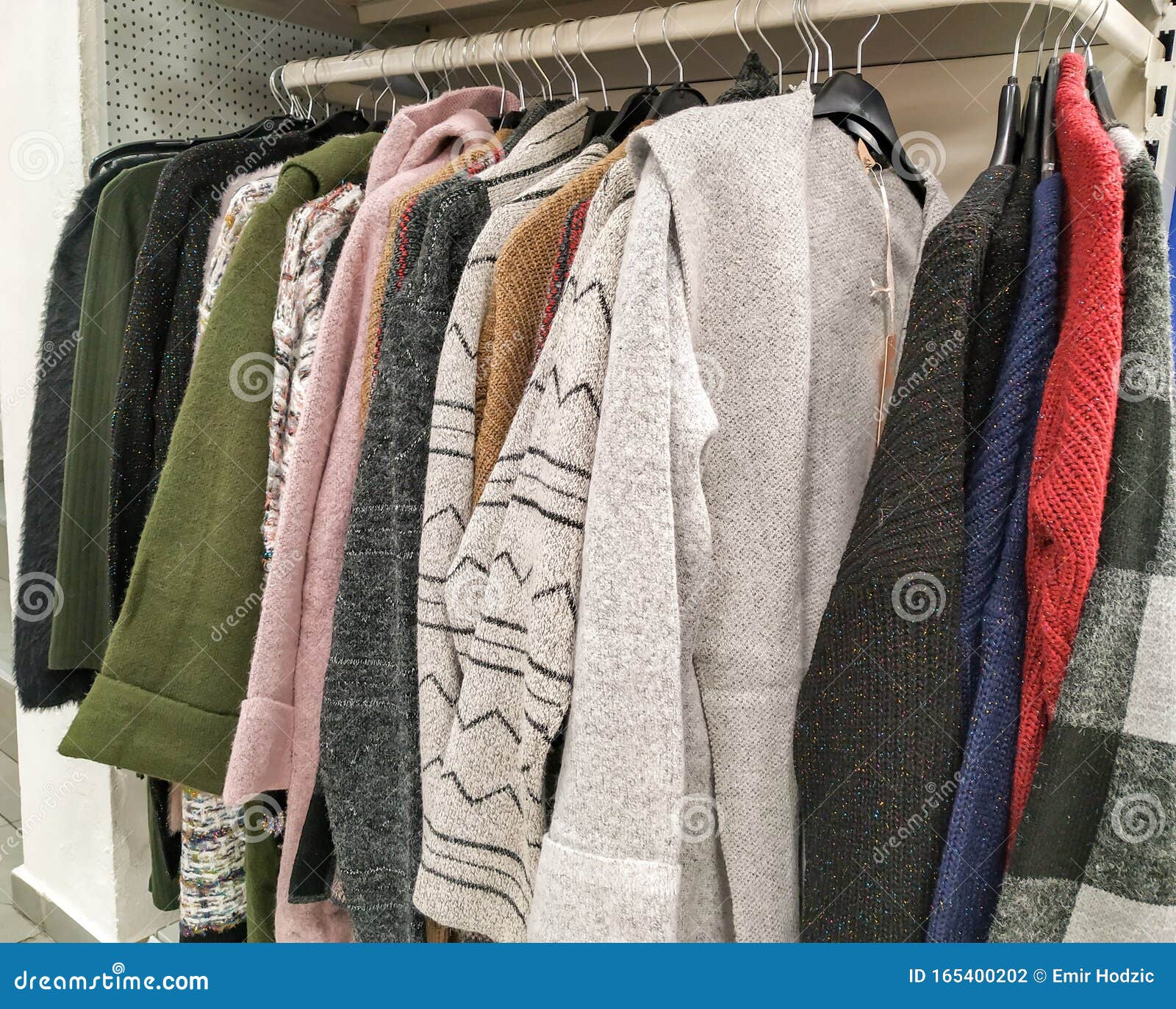 Collection Of Warm Winter Clothes Hanging Organized In A Cabinet
