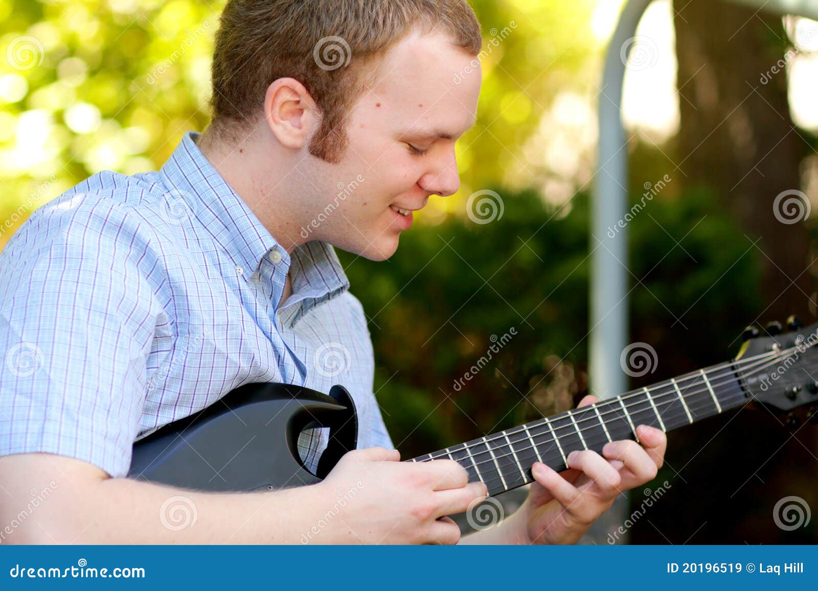 college boy concentrating on guitar