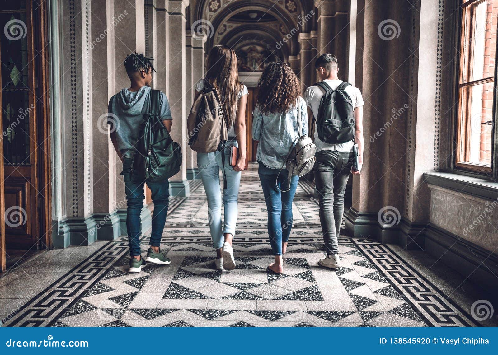 college life. group of students are walking in university hall and chatting