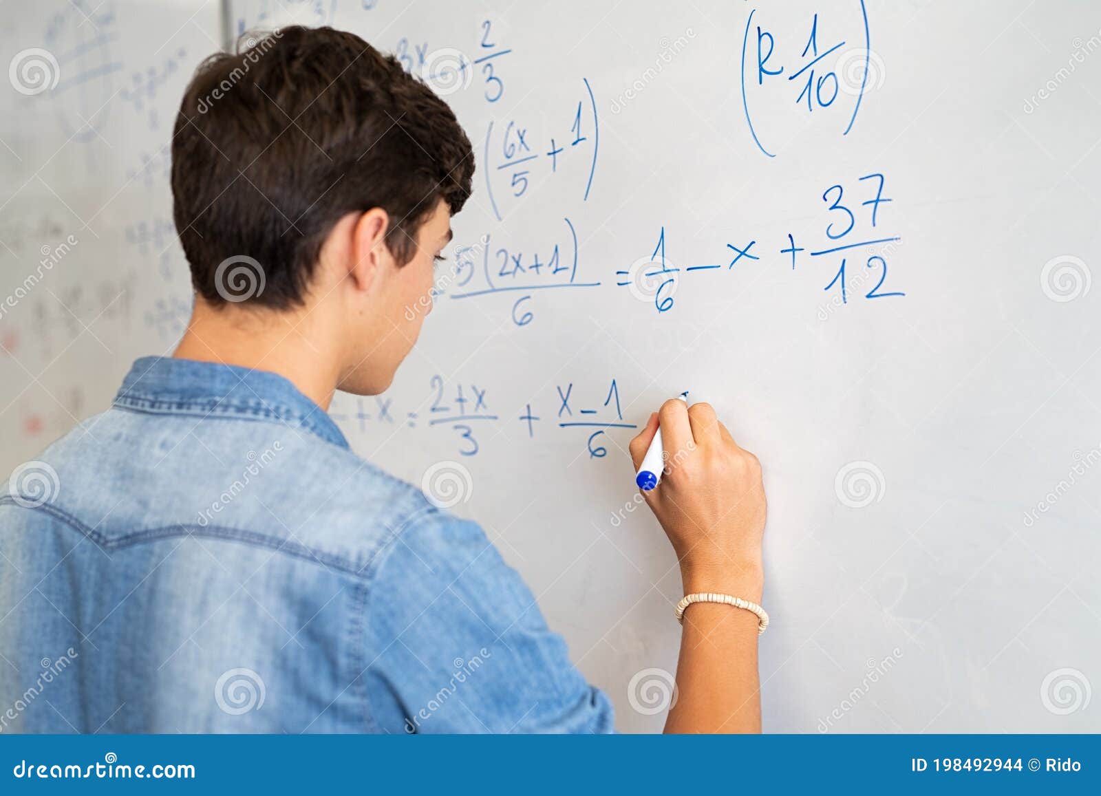 college student solving math equation on white board