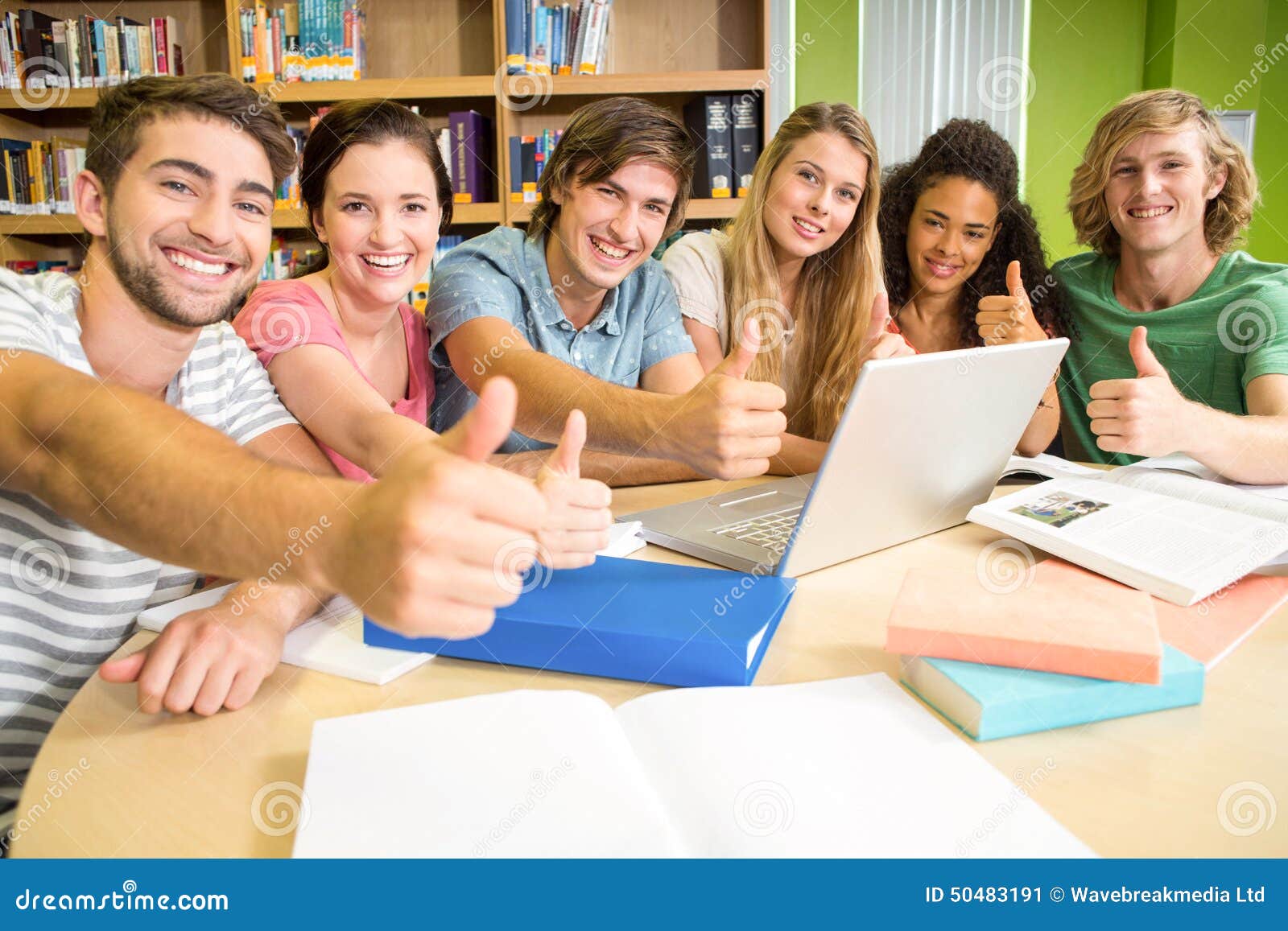 College Students Gesturing Thumbs Up In Library Stock Image