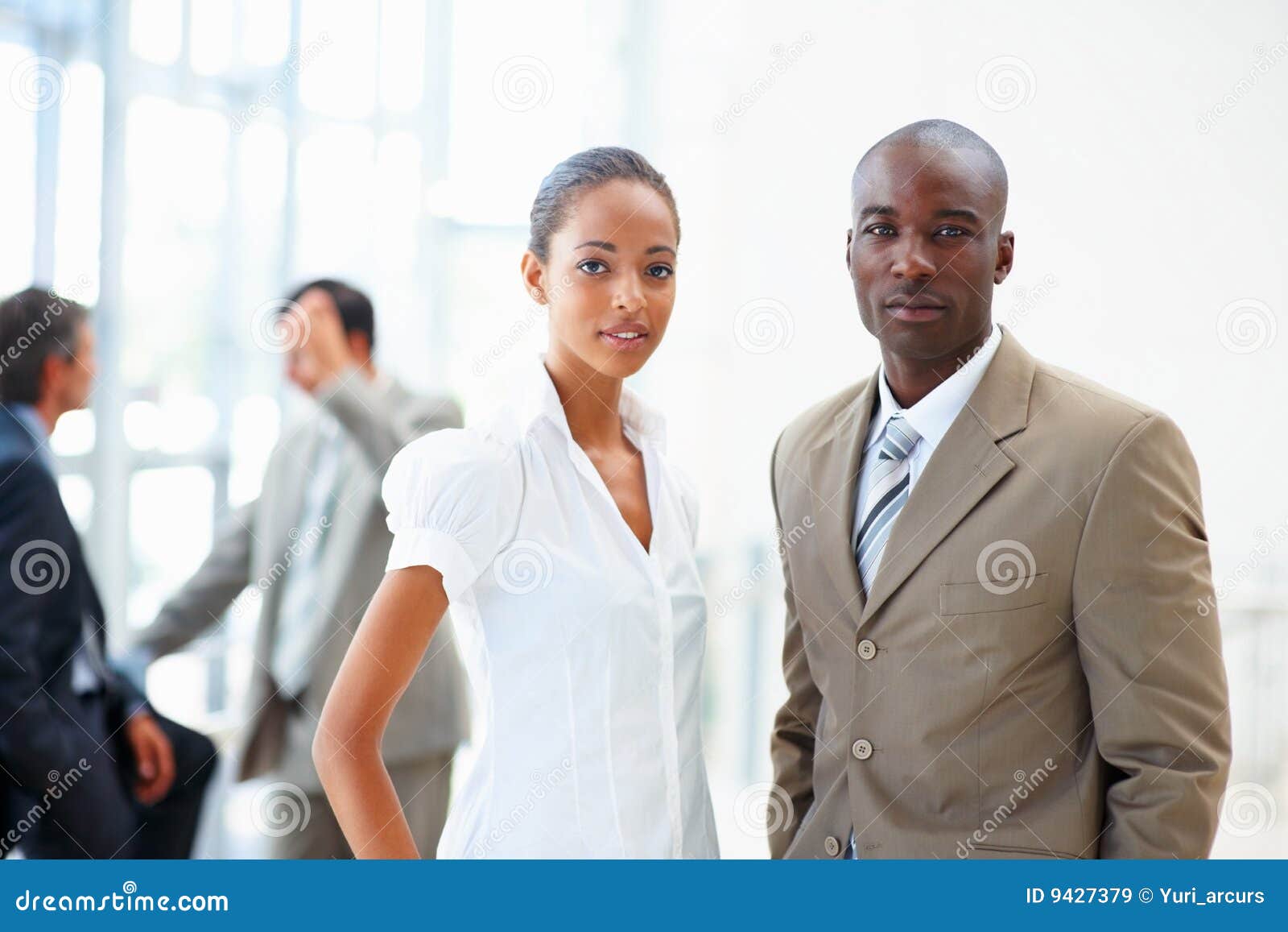 Ritratto dei colleghi professionali di affari che si levano in piedi insieme nell'ufficio