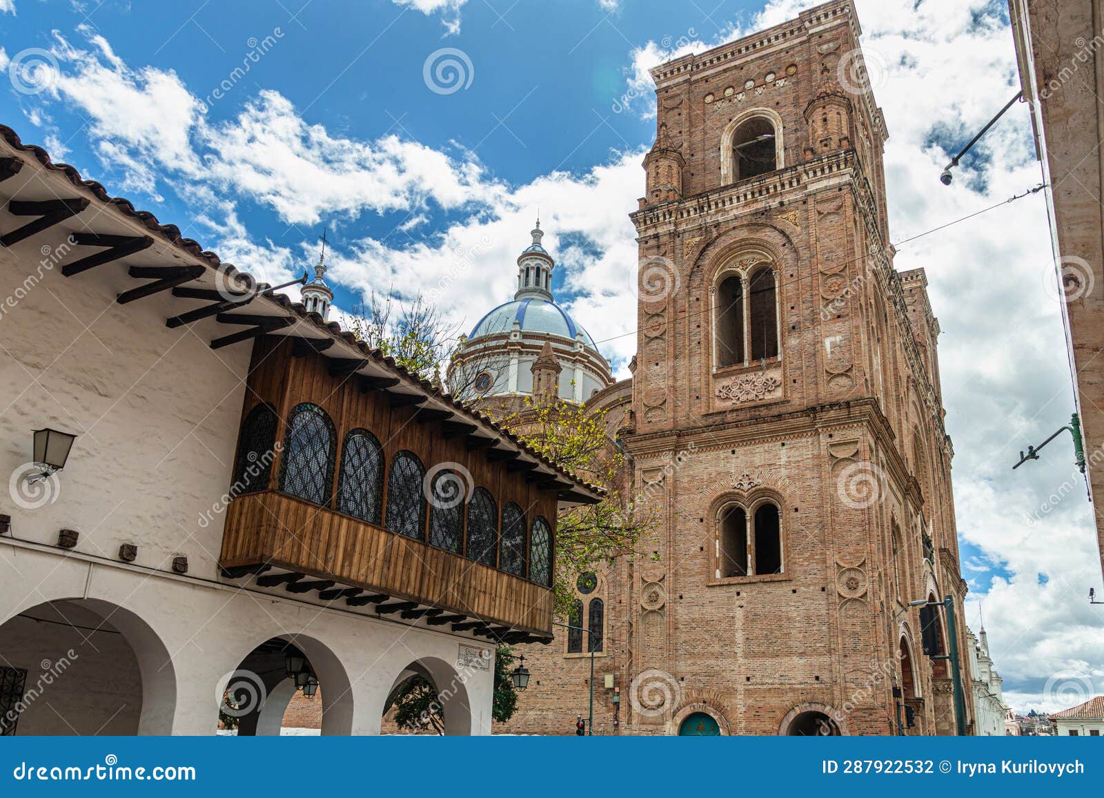 colonial building with balcony and cathedral in cuenca, ecuador