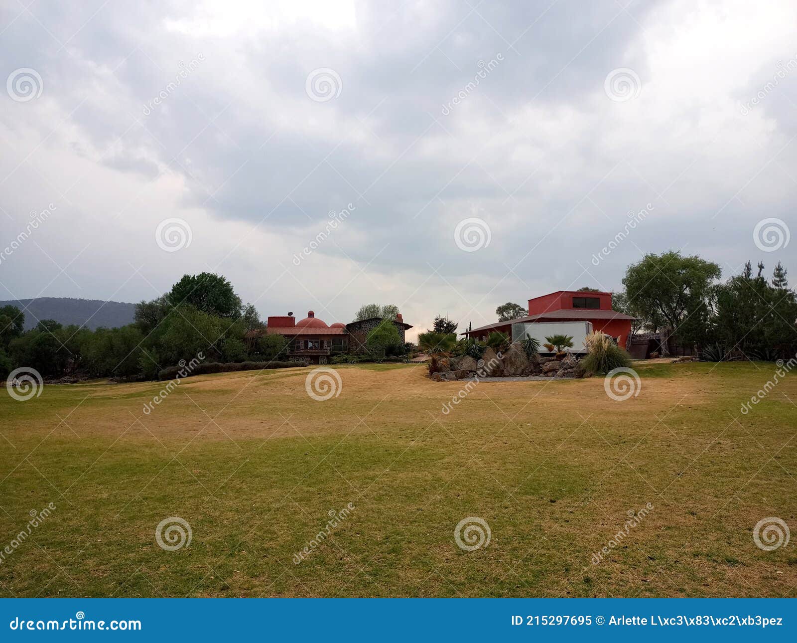 colonnial farm and country house, stone and red brick construction with arches and green grass garden