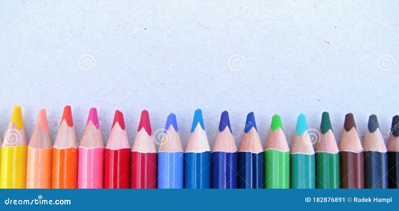 Colored pencil crayons in a row on white background Background