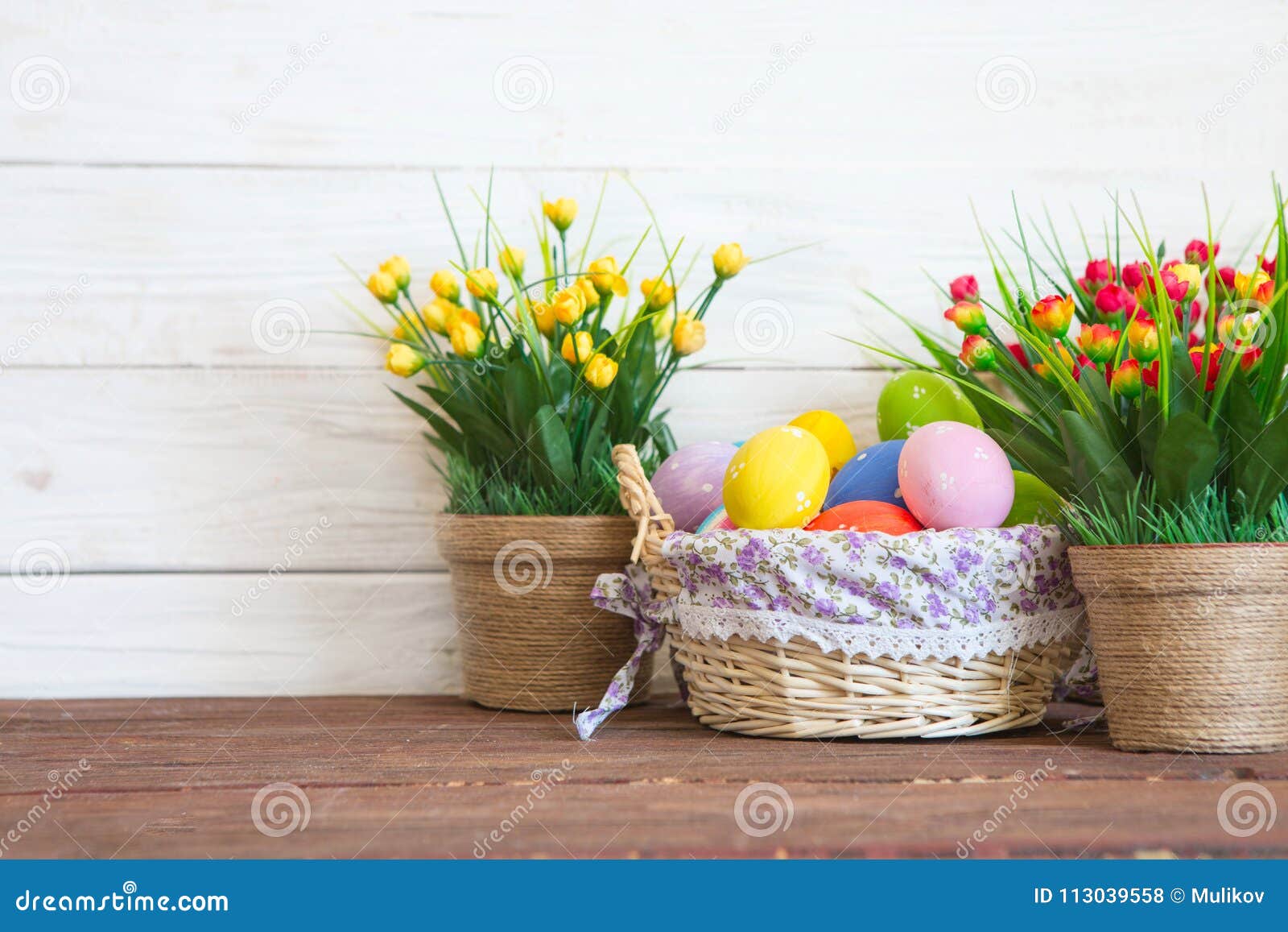 Colored Easter Eggs In The Basket And Spring Flowers On Wooden B Stock ...