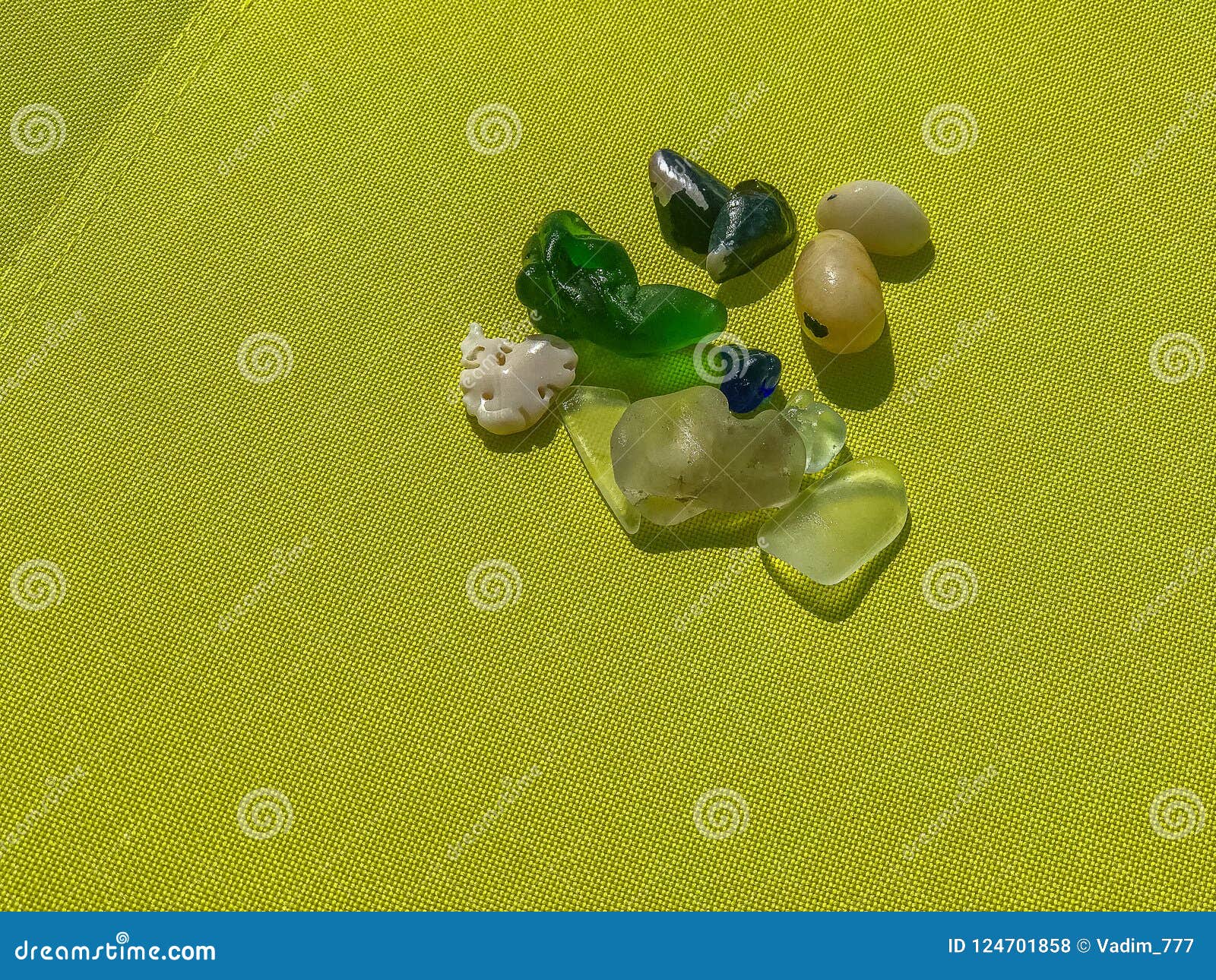 Colored Glass Pebbles in the Background of Canvas. Stock Photo - Image