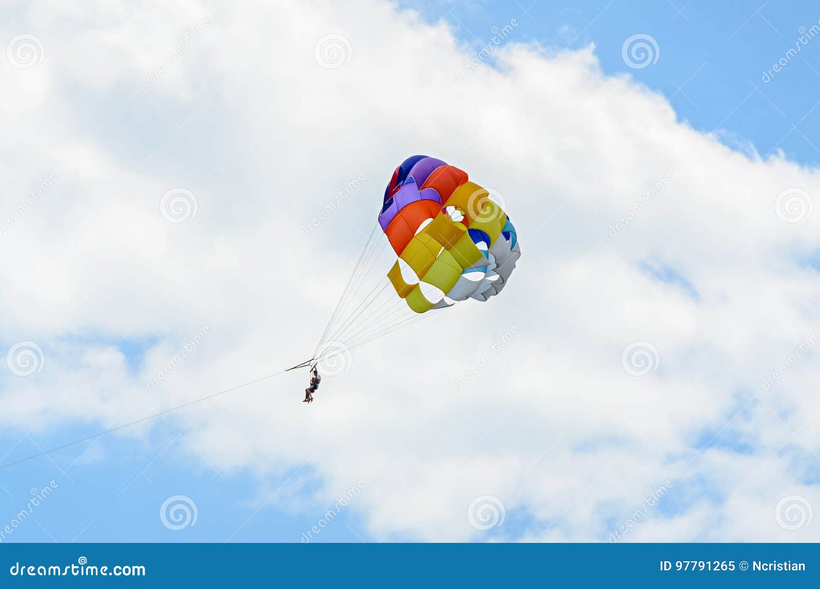 colored parasail wing in the blue clouds sky, parasailing
