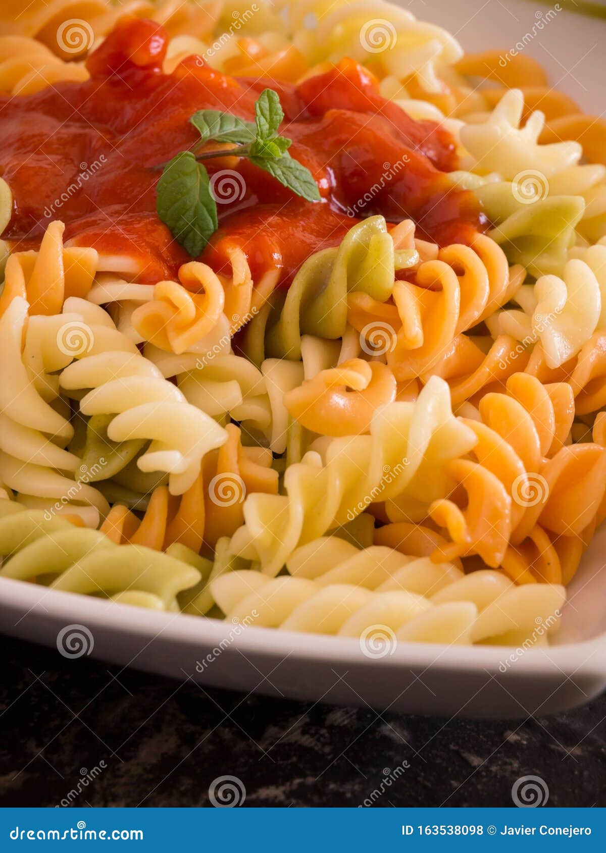 Colored Pasta with Tomato Sauce on Plate Close Up Stock Photo Image