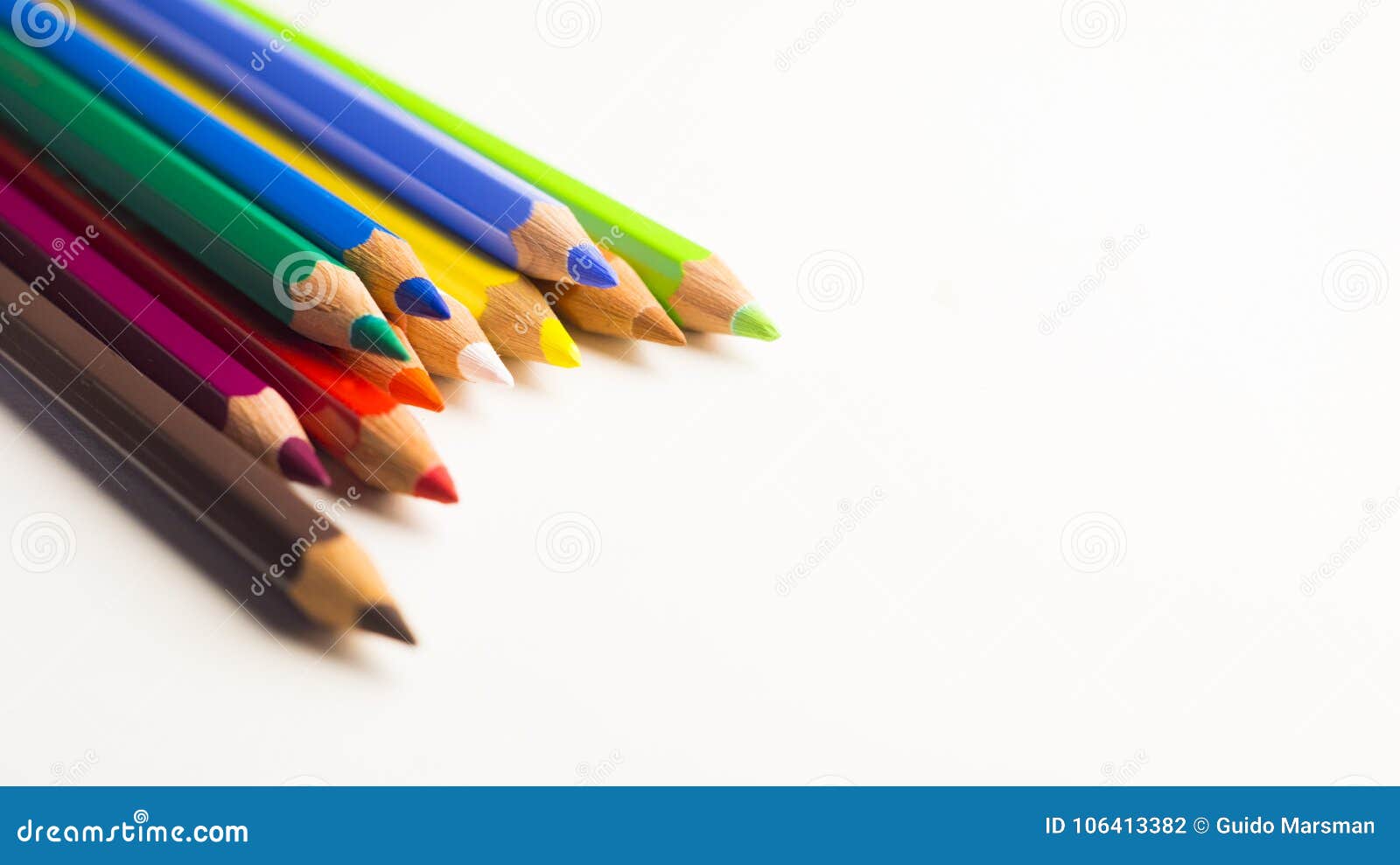 Colored Pencils Laying in Left Corner on White Background Stock Photo