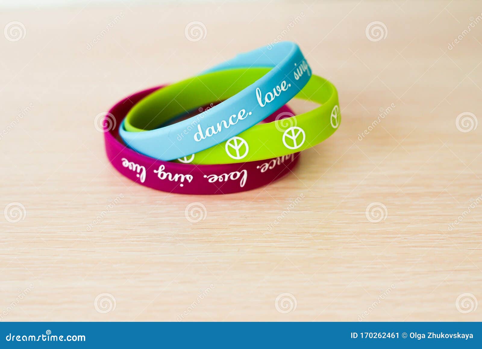 colored rubber bracelets with inscriptions on beige background