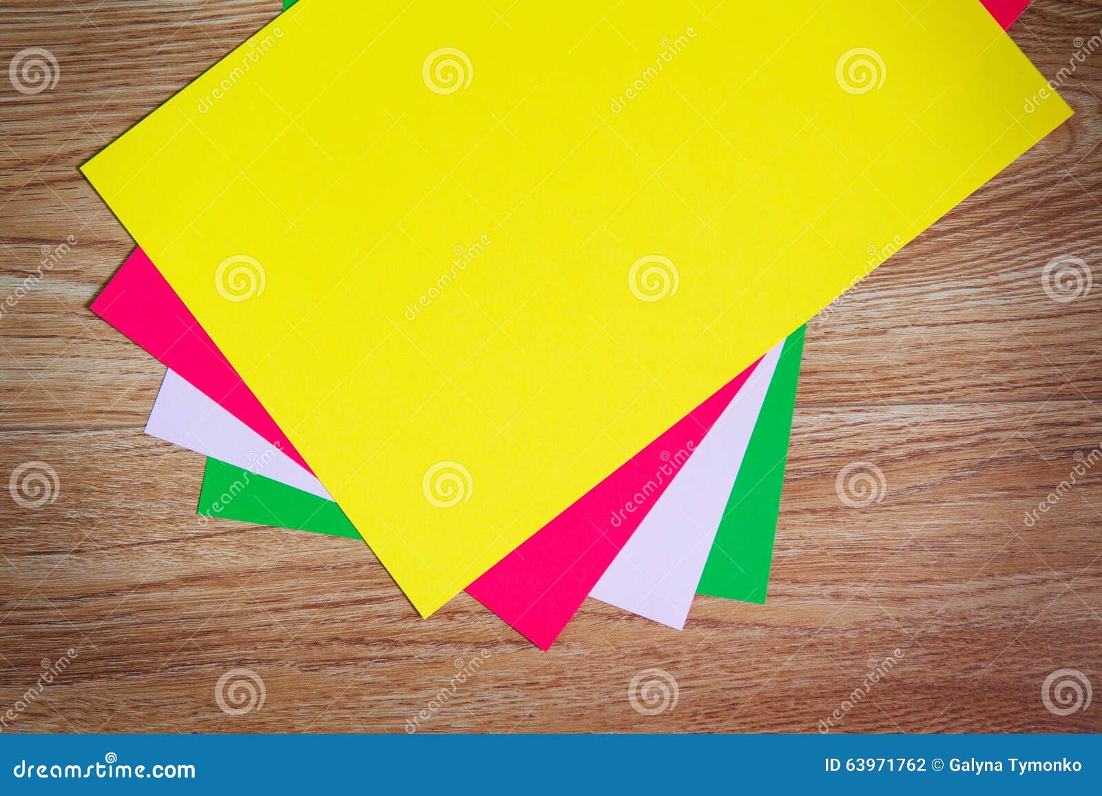 Colored Sheets Of Paper Stacked On A Wooden Floor Stock Photo