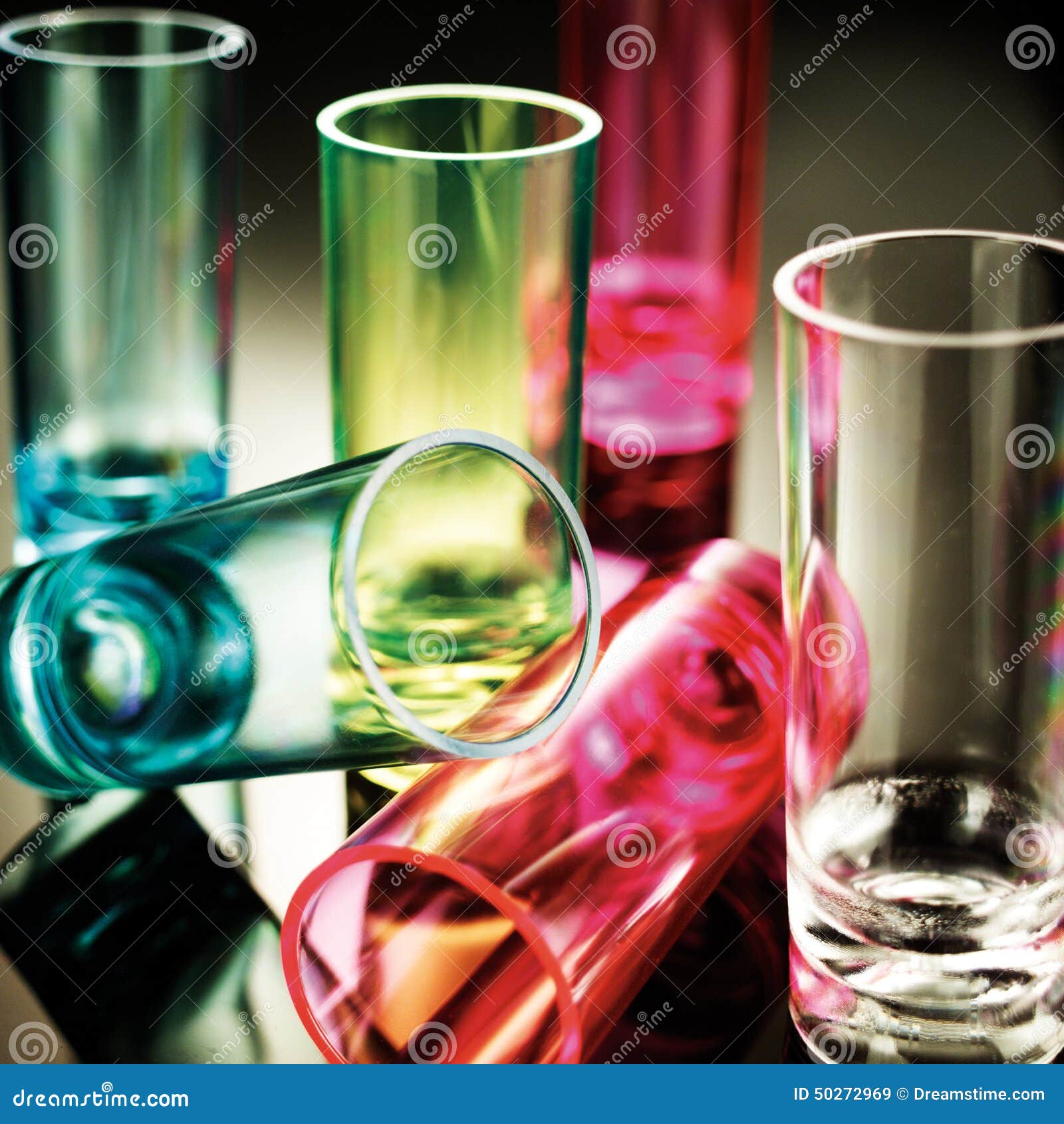 Colored Shot glasses. Blue,green,pink and clear shot glasses on a mirrored background