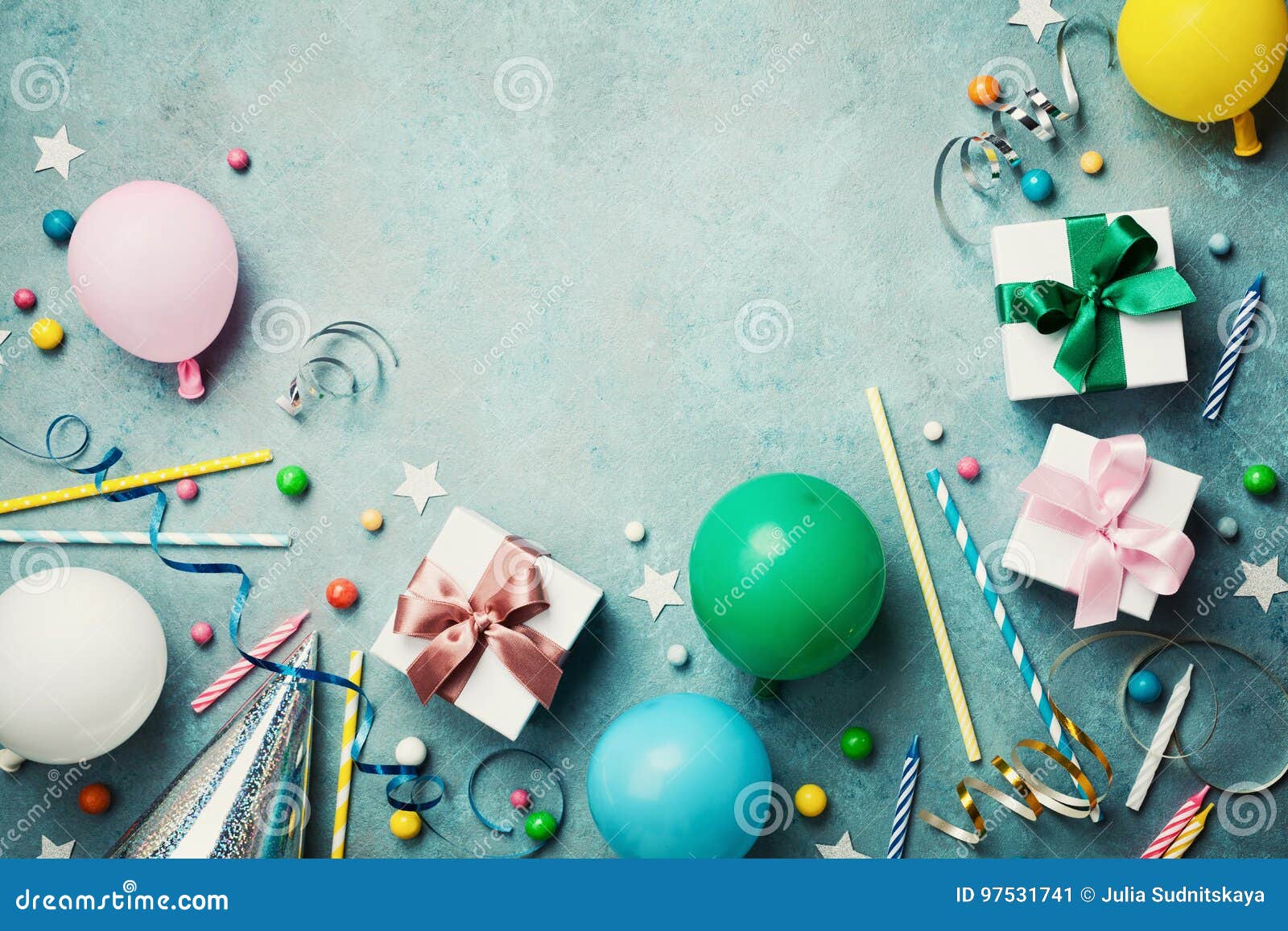 Colorful balloon, present or gift box, confetti, candy and streamer on vintage turquoise table top view. Birthday background. Colorful balloon, present or gift box, confetti, candy and streamer on vintage turquoise table top view. Birthday or party background. Flat lay style. Copy space for text.