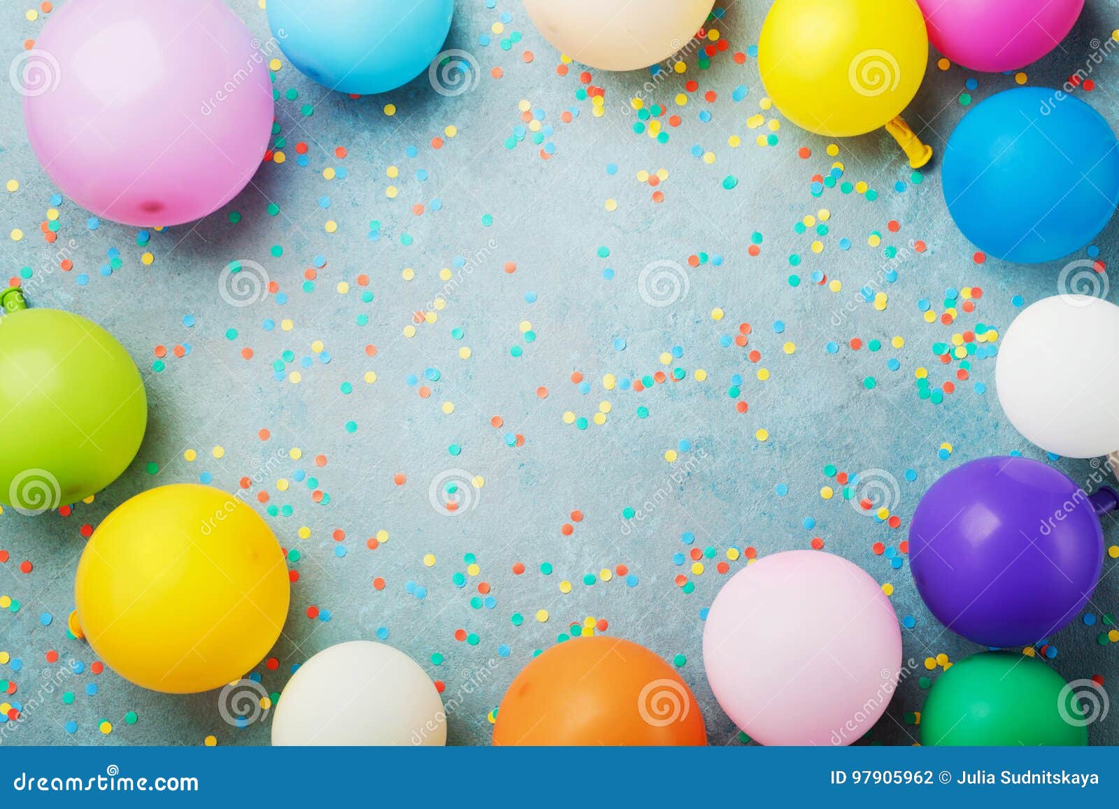colorful balloons and confetti on turquoise table top view. birthday, holiday or party background. flat lay style.