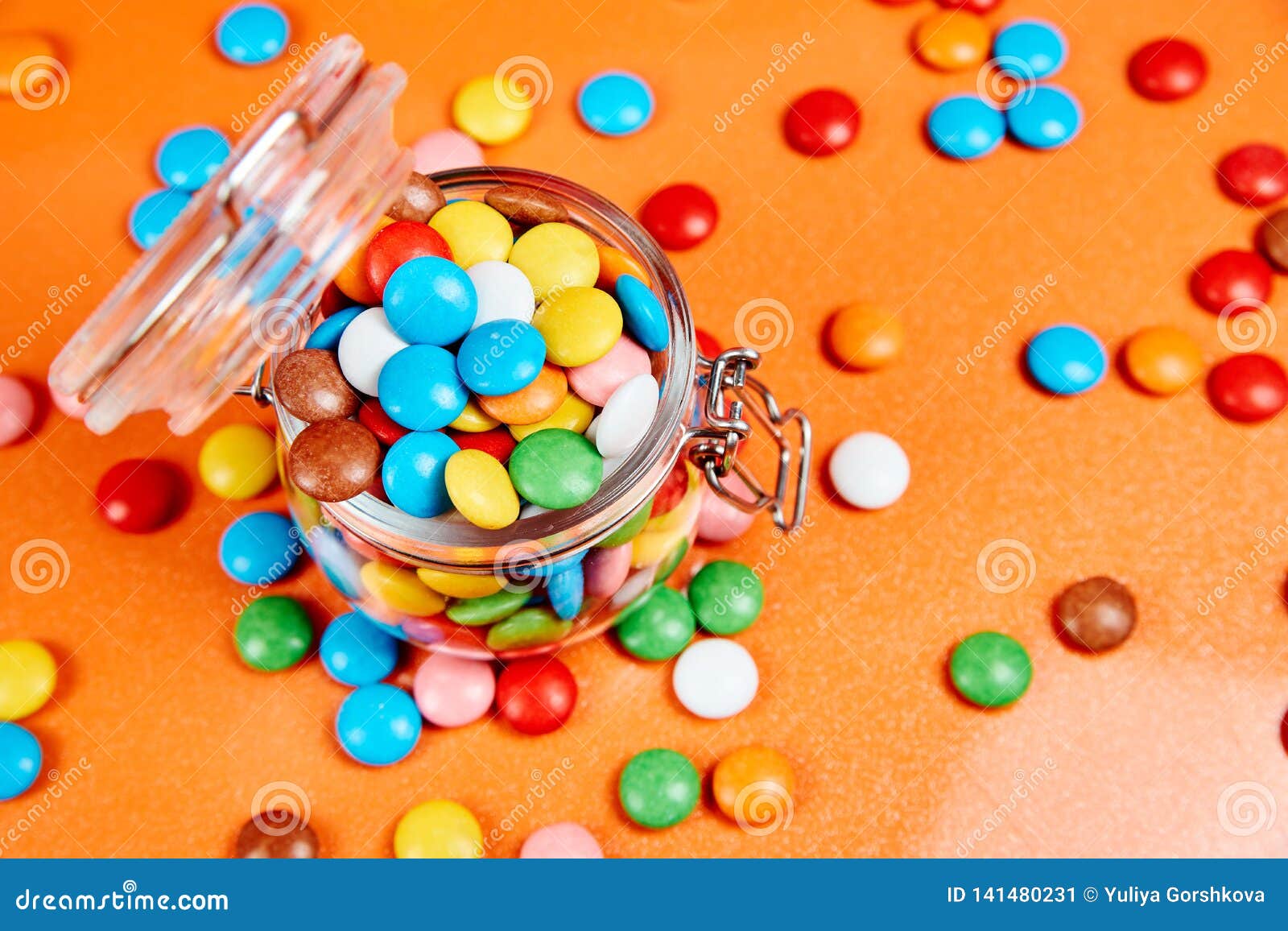 Colorful Candies in Glass Jar on Red Oranges Background Stock Image ...